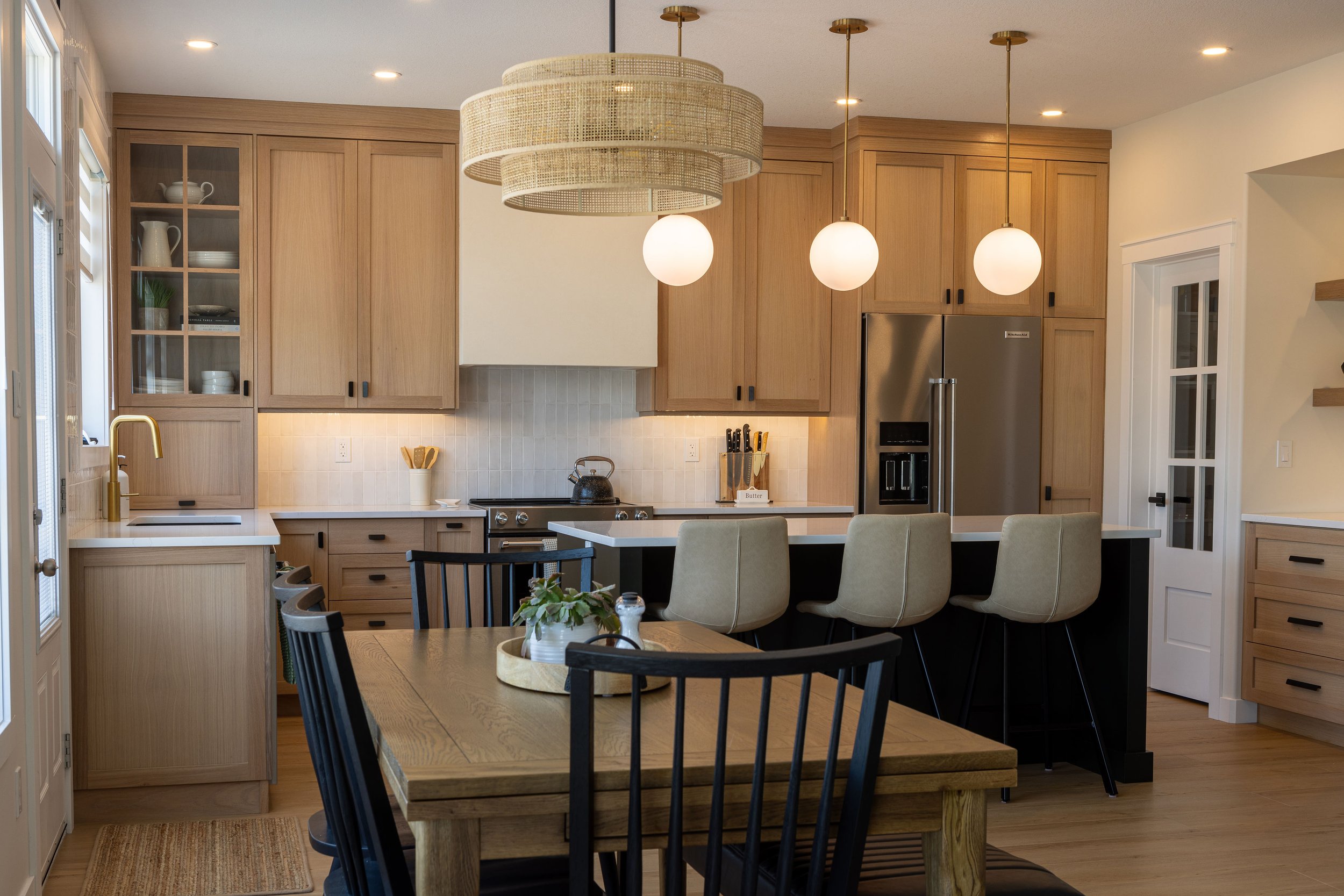 White Oak cabinetry with dark island and stucco hood