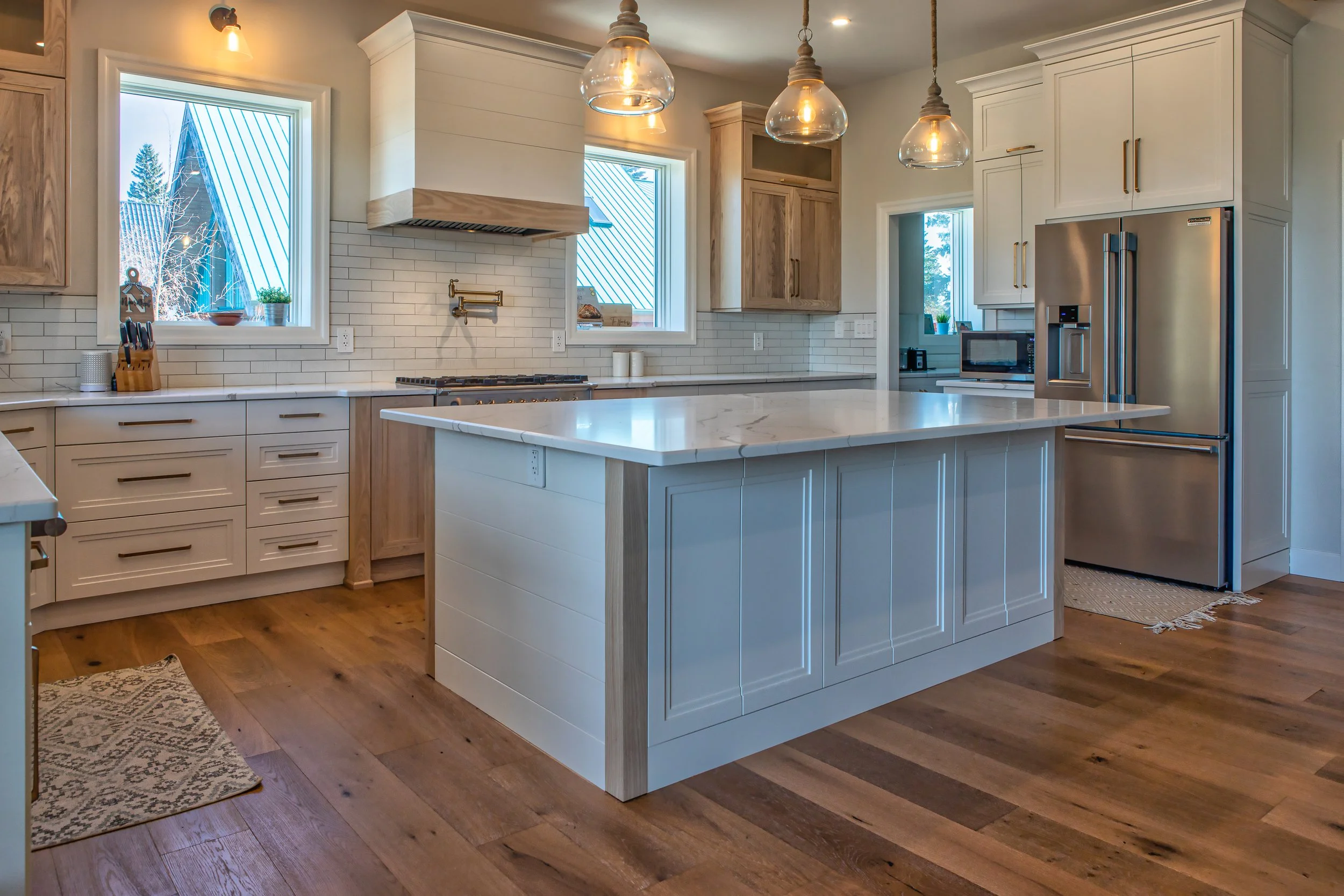 White Kitchen with light wood accents and shiplap hood