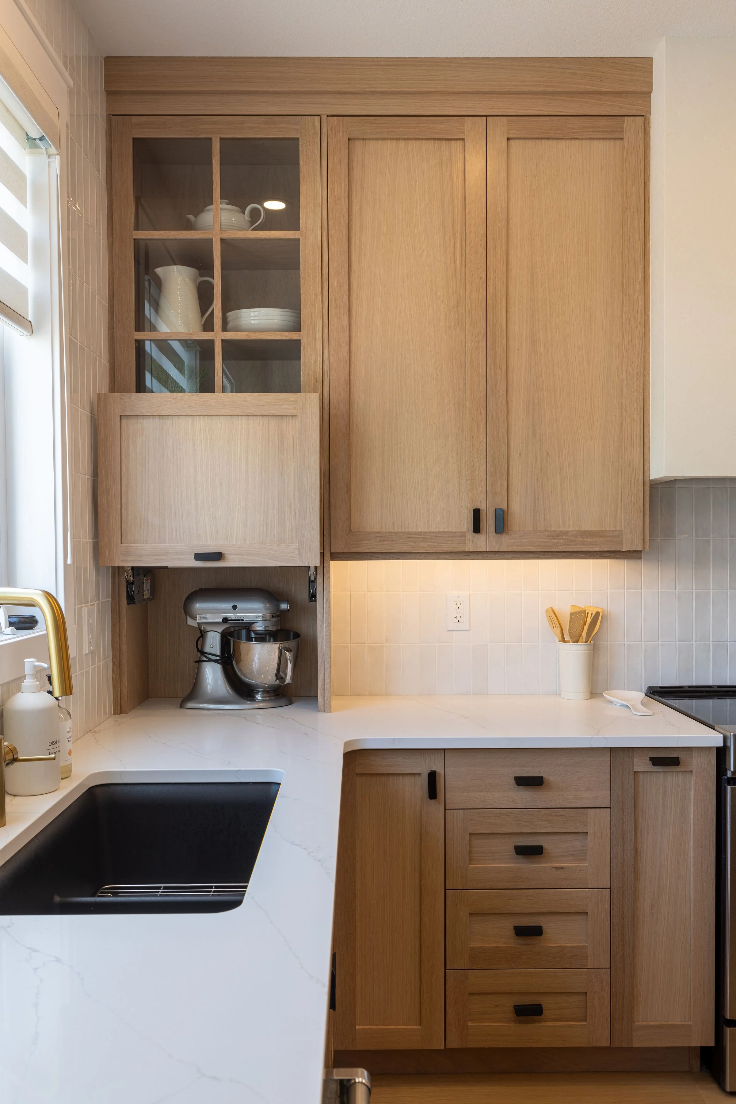 White Oak cabinetry with hidden mixer flip up