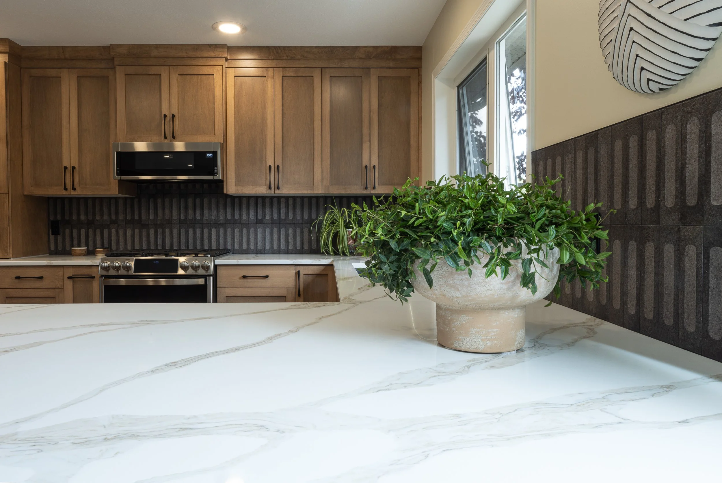 Maple cabinets with white quartz and black tile
