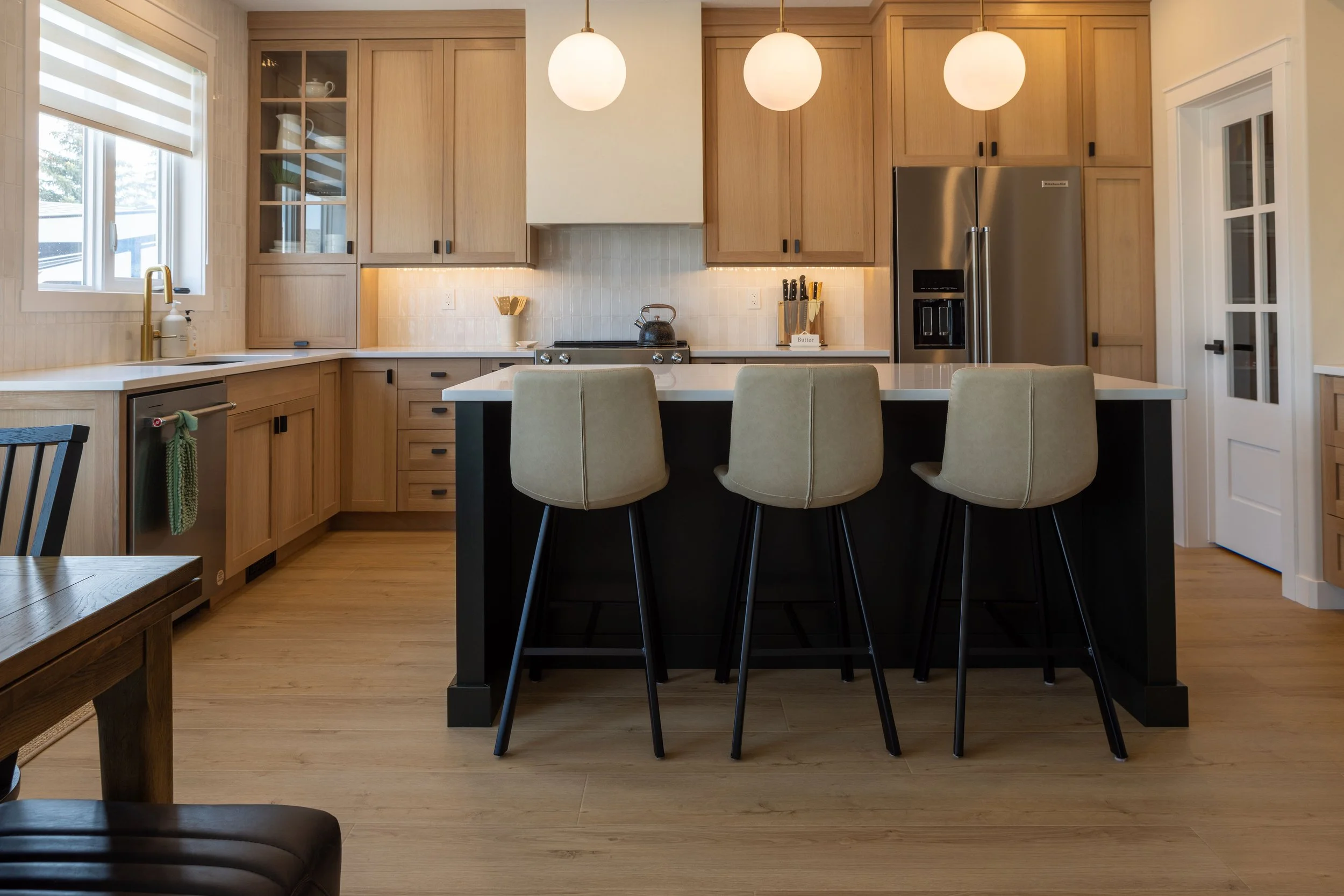White Oak cabinetry with Dark Green Island and Stucco Hood