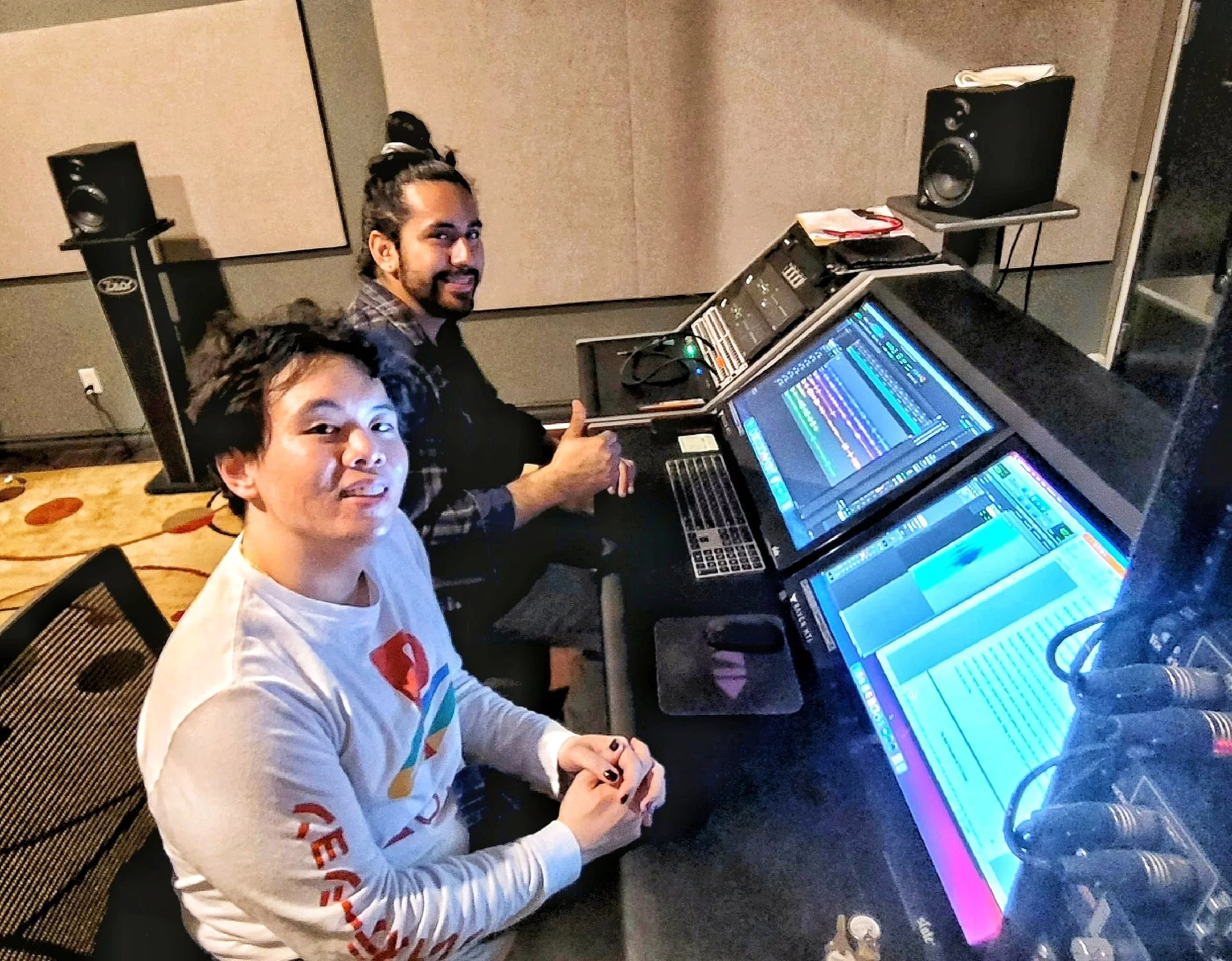 Two Wichita State University student engineers seated at the Shocker Studios mixing console.