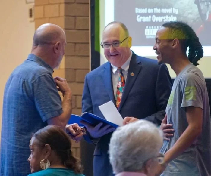 Grant Overstake speaking with attendees at Holy Savior Academy listening event in Wichita