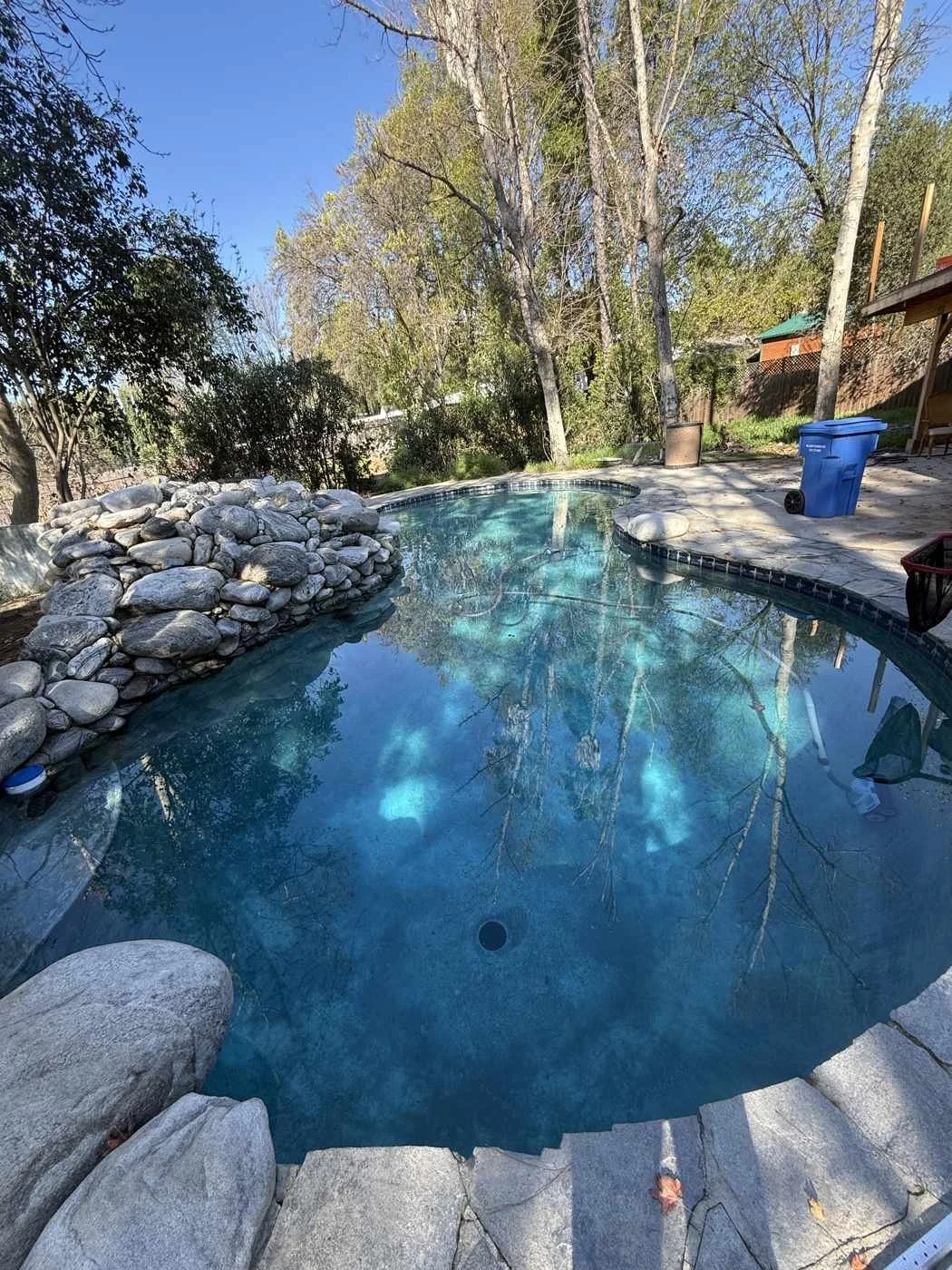 Natural stone lagoon-style pool maintained by County Line Pools in Agoura Hills, CA, surrounded by mature oak canopy