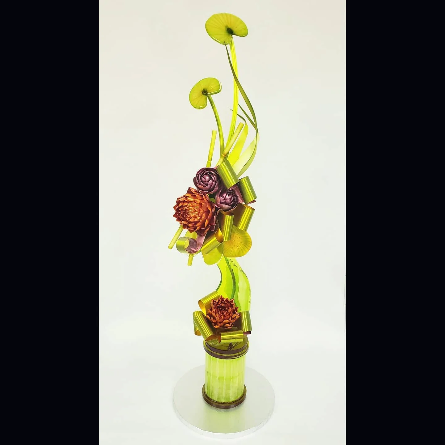 Spring themed sugar showpiece using natural greens, copper and deep purple. In color selection and design, I try to use no more than 3 colors. This piece features 2-sided ribbons with the complimenting colors on the inside.  My students did a great j