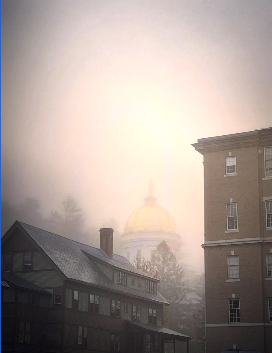 Morning fog surrounding a cityscape with a gold-domed building in the background, partially obscured by mist.