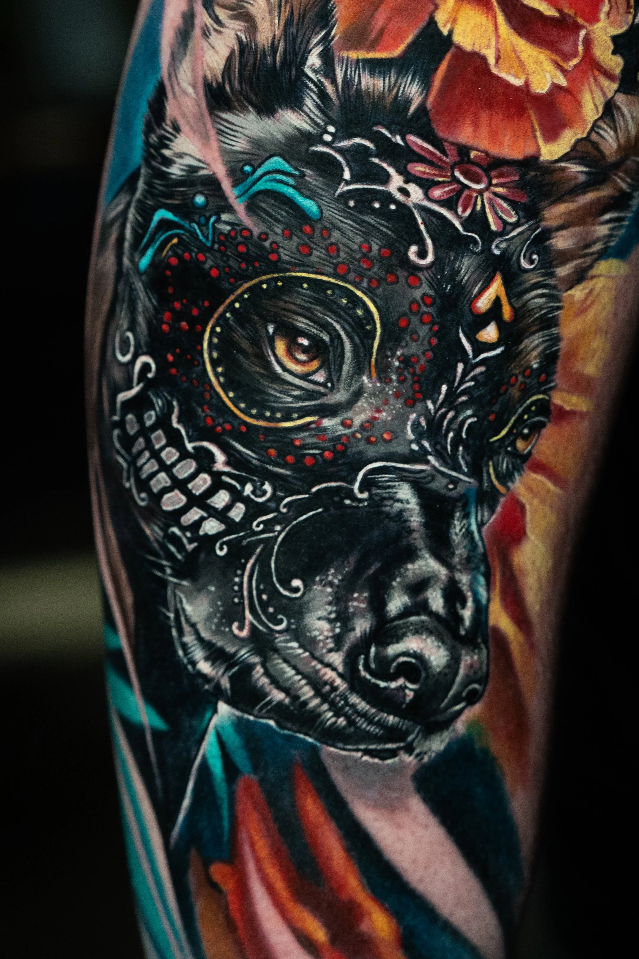 Colorful tattoo of a Xolo dog with intricate decorative elements and vibrant background colors.
