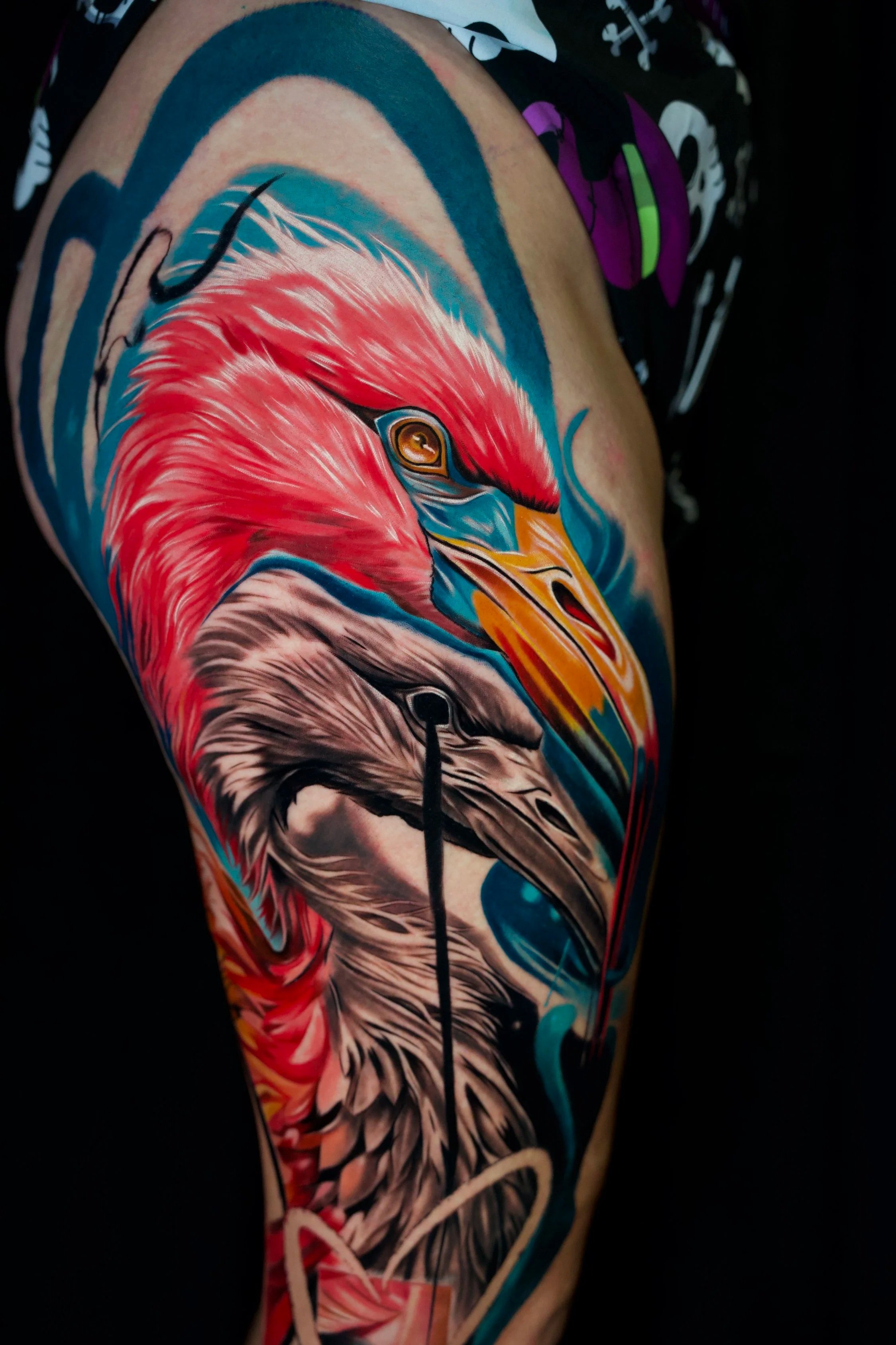 Colorful tattoo of a phoenix and an eagle on a person's arm.