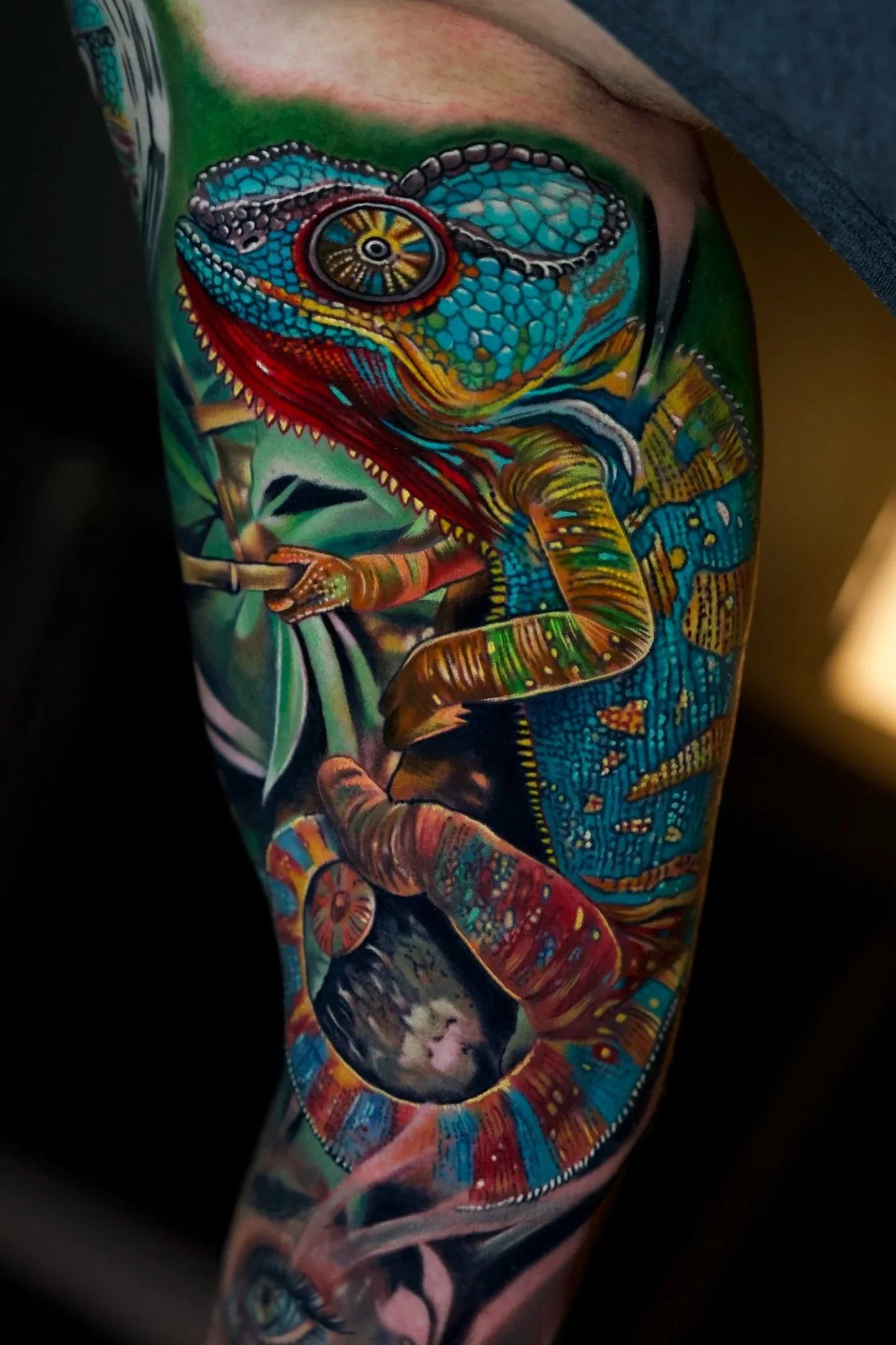 Colorful tattoo of a chameleon on a person's arm with detailed scales and vibrant colors.