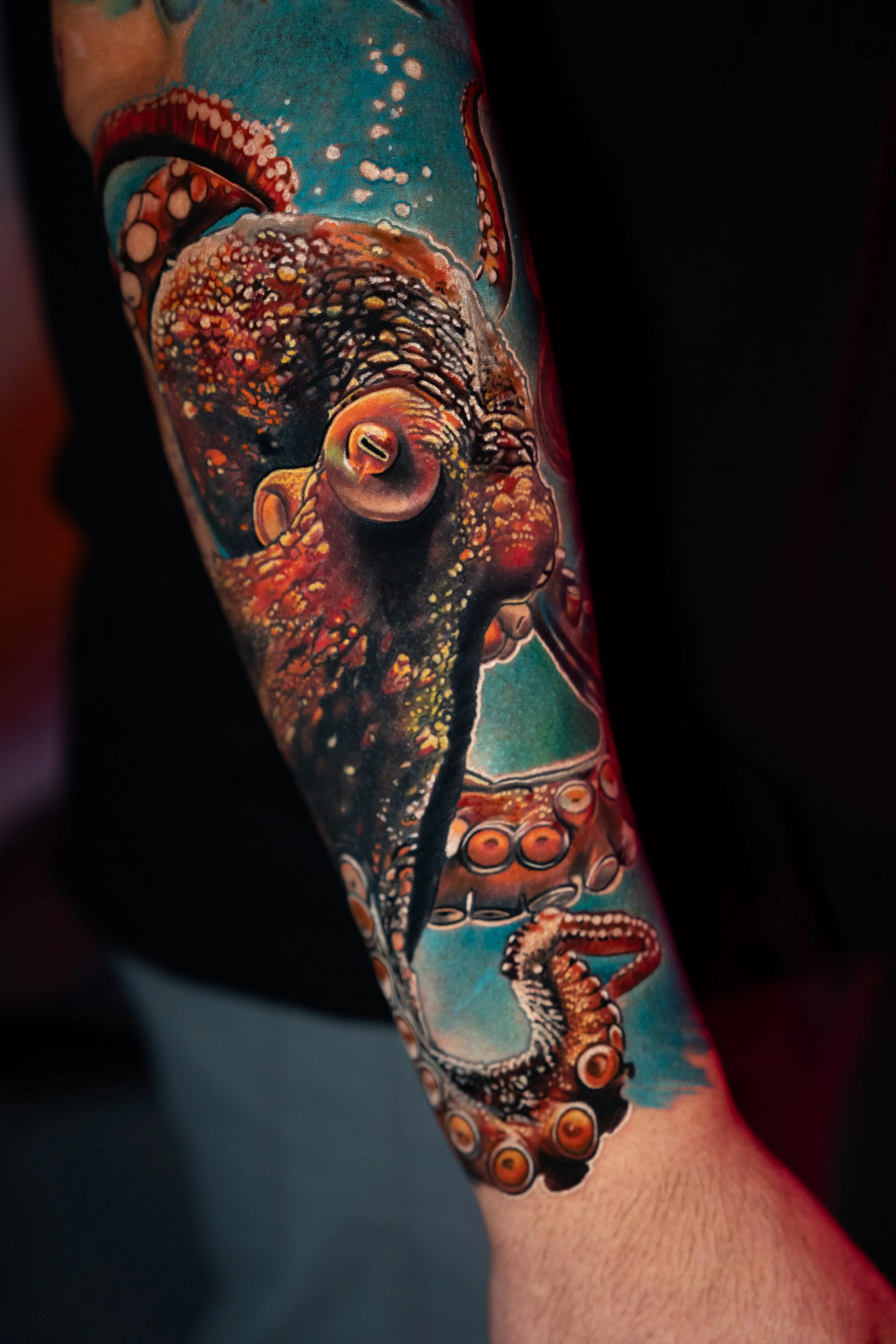 A detailed tattoo of an octopus on a person's arm, featuring vivid colors and intricate shading.