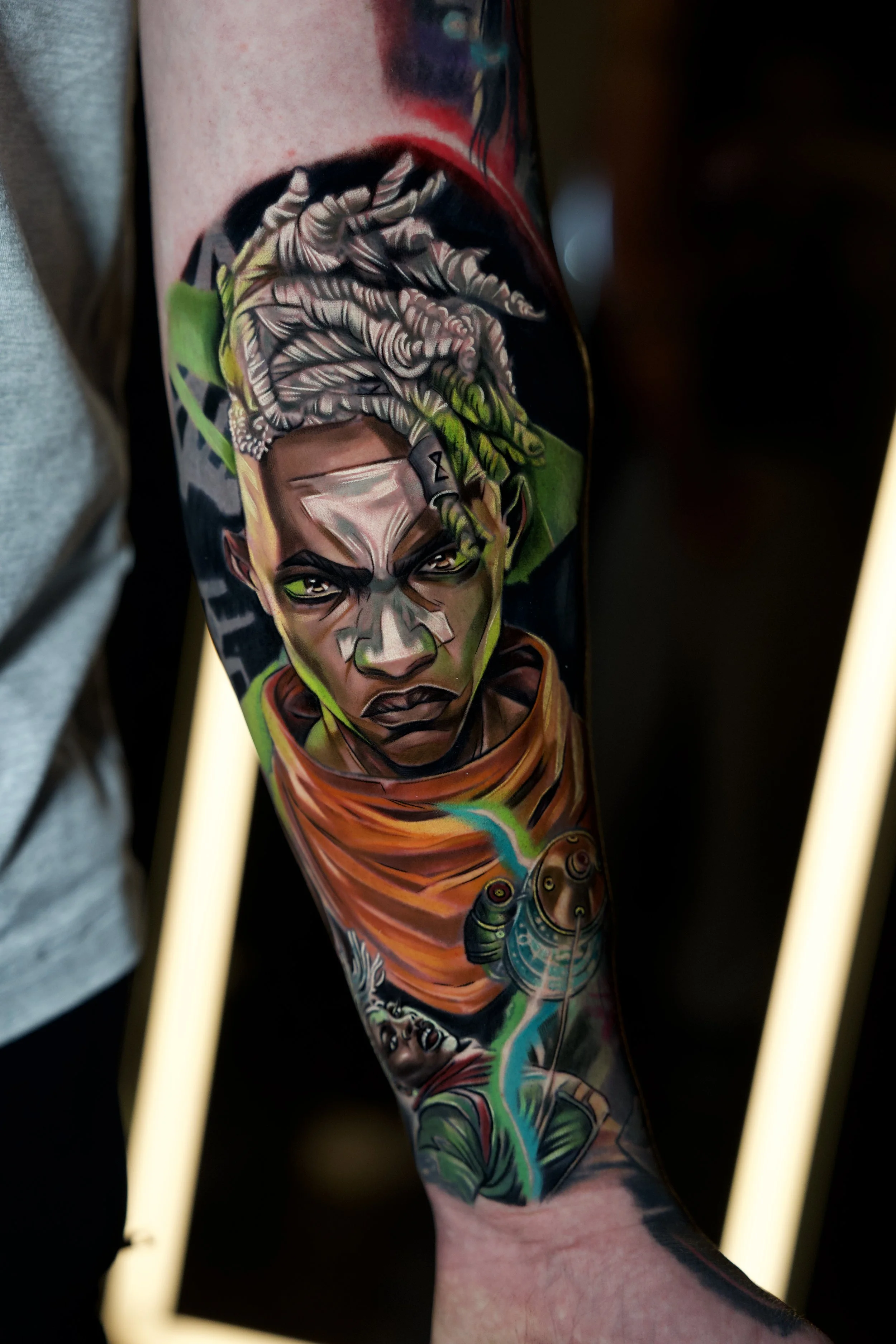 Colorful tattoos on a person's arm, featuring Ekko from Arcane, a fierce-looking man with braided hair, a lightning bolt, and a battling figure, with vibrant green, orange, and blue accents.