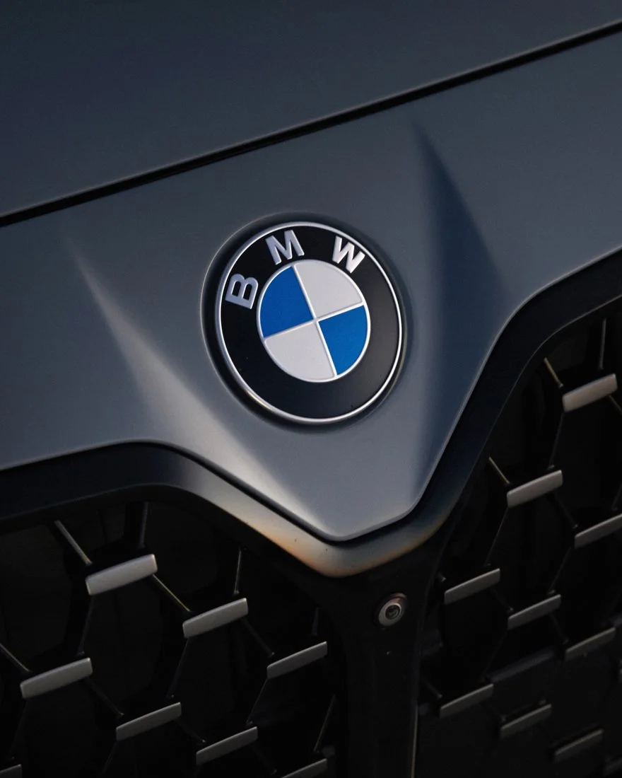 Close-up detail of the BMW roundel badge photographed for a luxury automotive advertising campaign