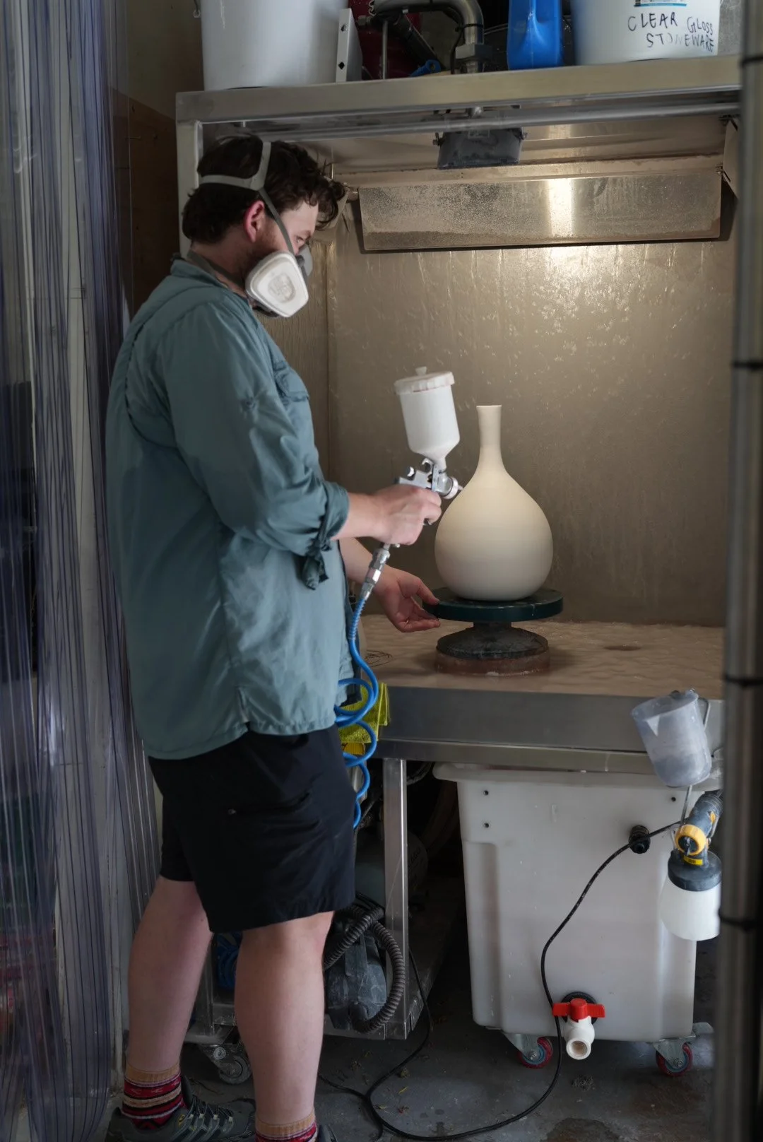 Water curtain spray booth with compressor for applying glaze.