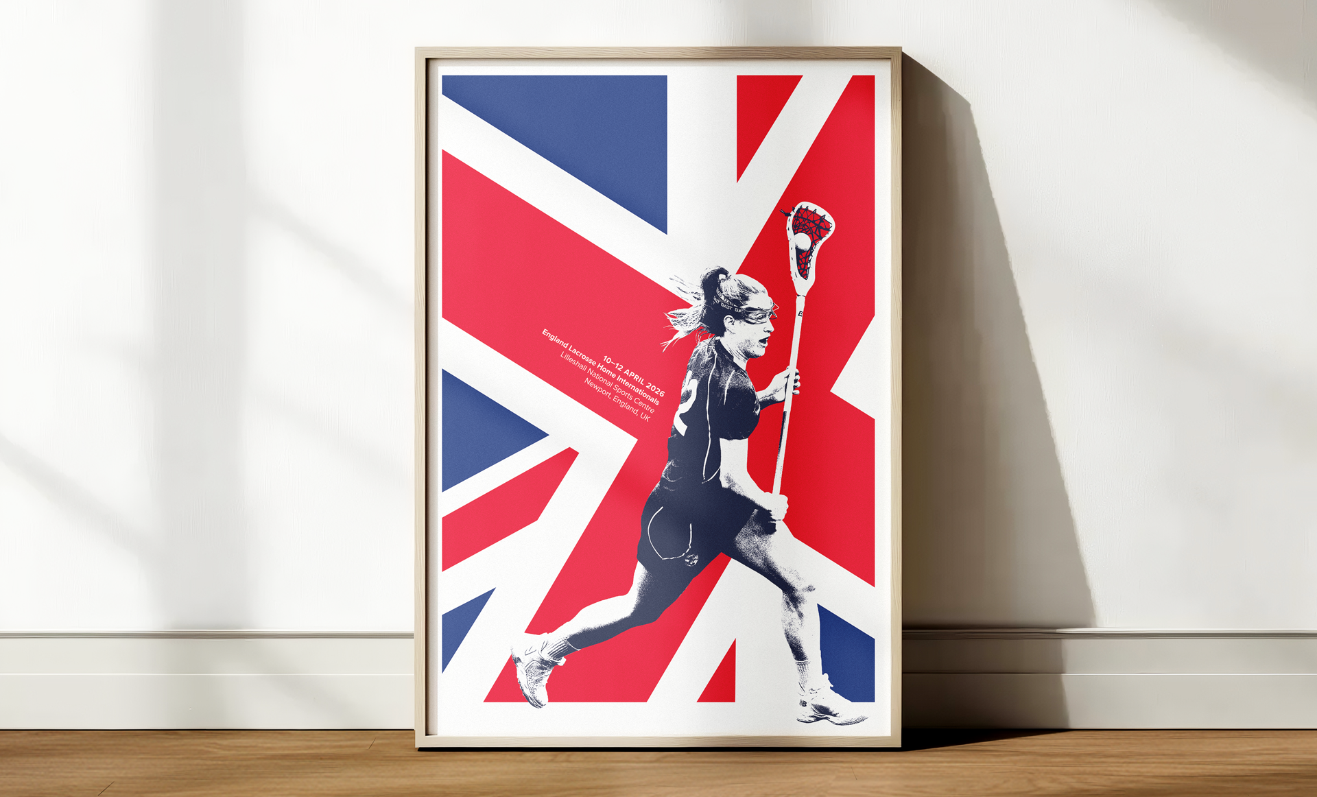 England Lacrosse Home Internationals poster design, featuring a Union Jack flag and a lacrosse player in full stride, shown framed and leaning against a wall.
