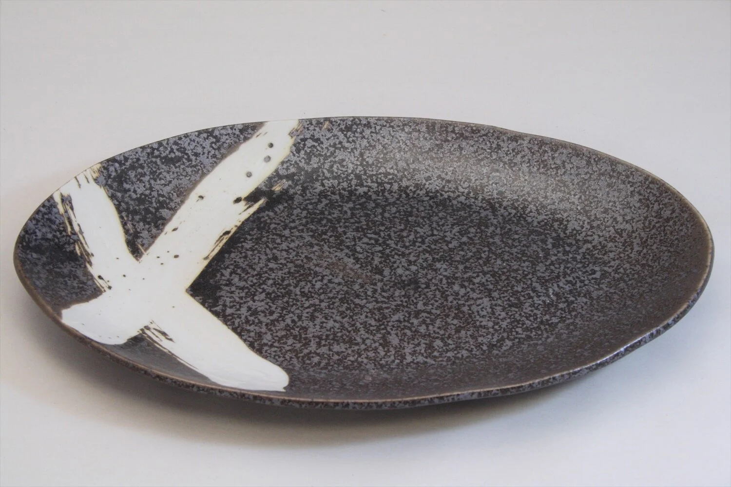 128-6171 White cross on black oval dinner plate