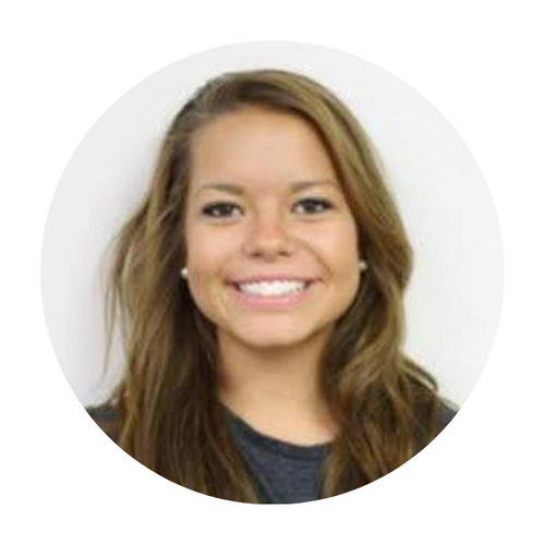 Portrait of a young woman with light brown hair and a big smile, wearing a dark top, in front of a white background.