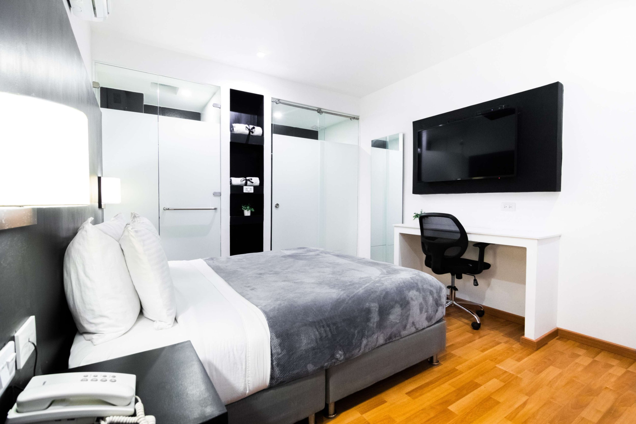 Habitación de hotel con cama, escritorio, silla y televisión