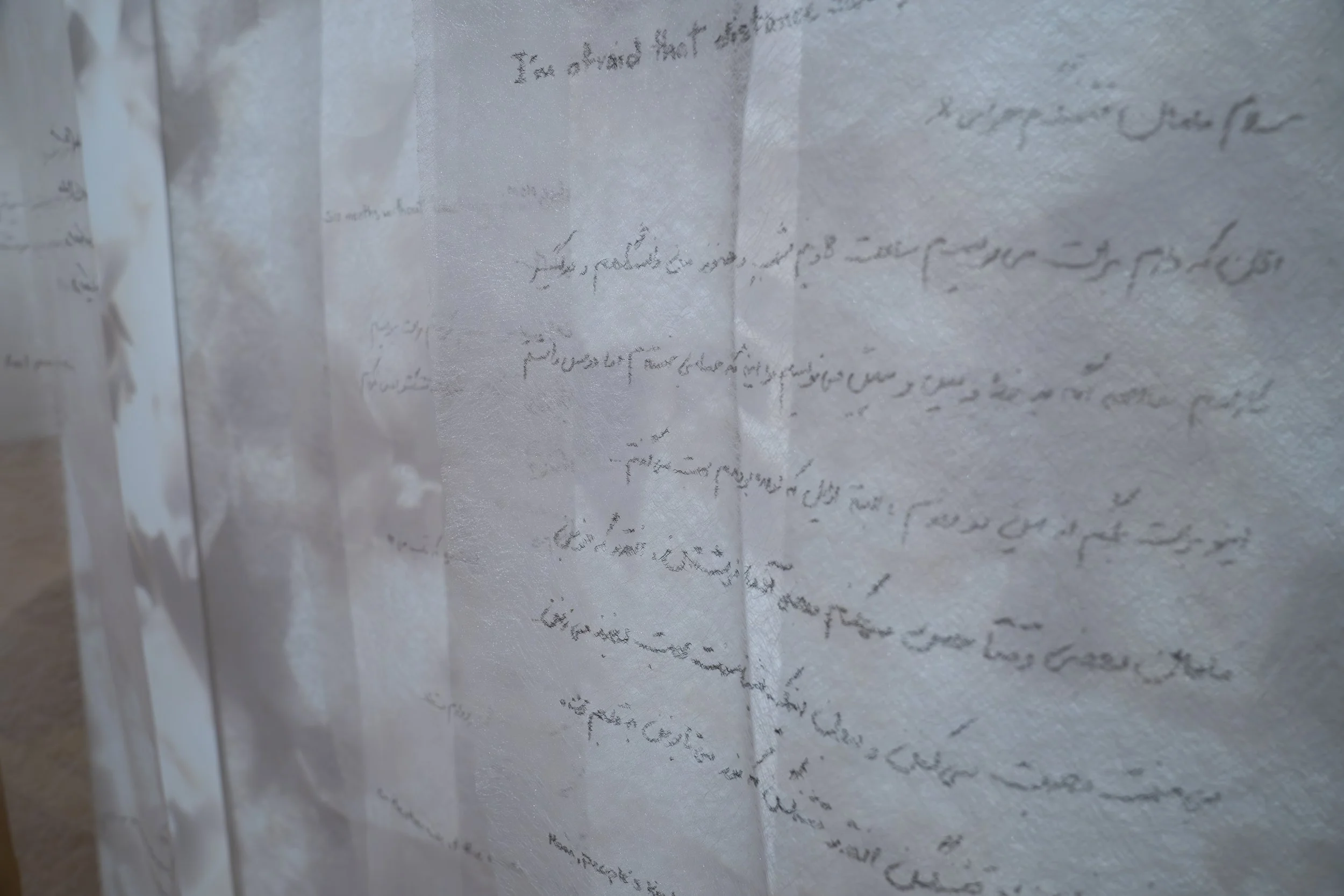 Zahra Momeni ,
Your Trace in the Farthest Nearness, 
2026, 
Mixed-media installation with overhead  
projection, photograms, transparent fabric,  
and handwritten text. 
Dimensions variable 