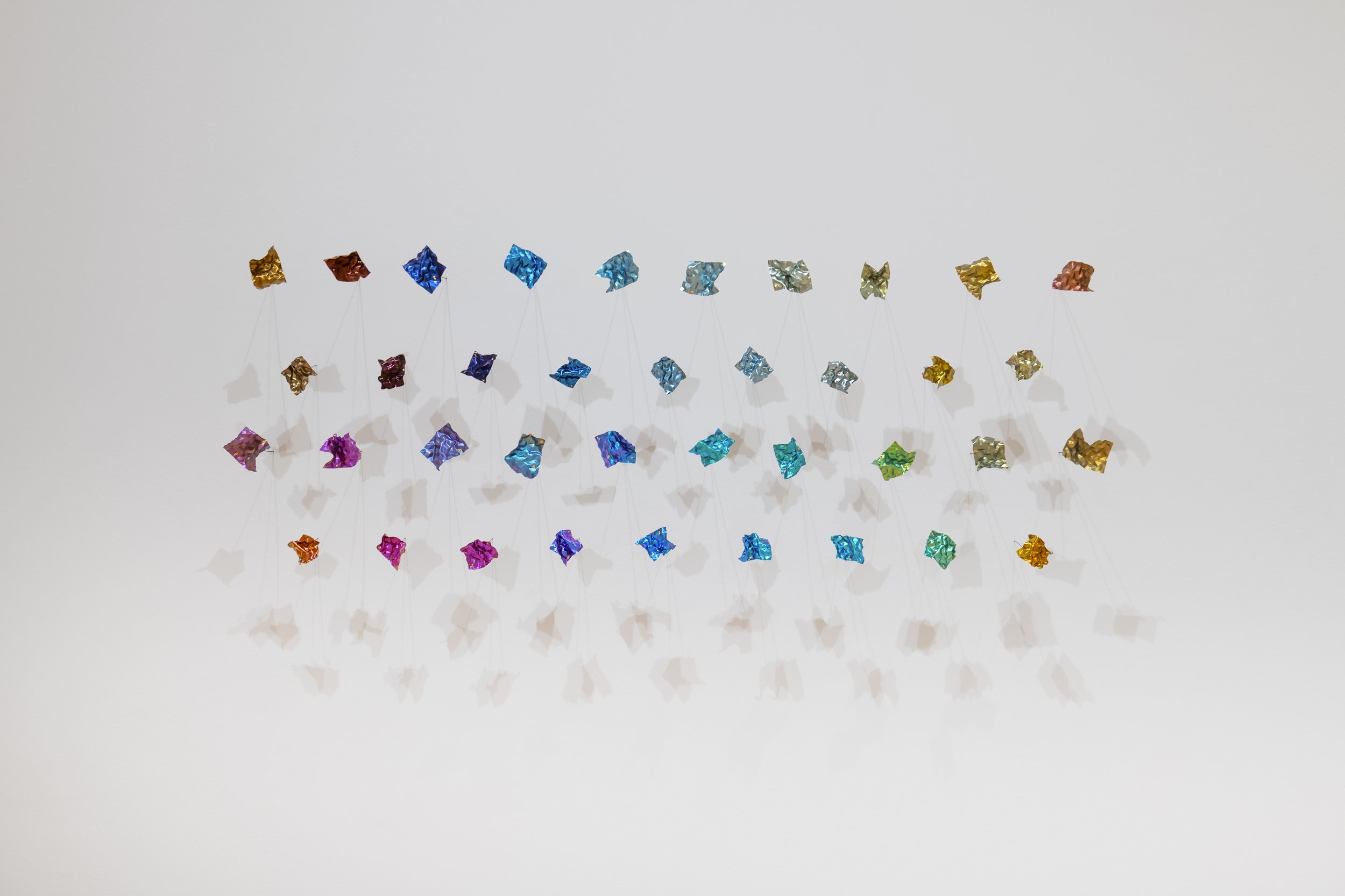 "Quiet fragments: (38 brooches made with anodized titanium and niobium)"
Titanium, Niobium, gold foil. Dimensions variable: 38 pieces in total, individual one is around 
2.7”x1.5”x0.007” 
Photo credit: John Carlano
