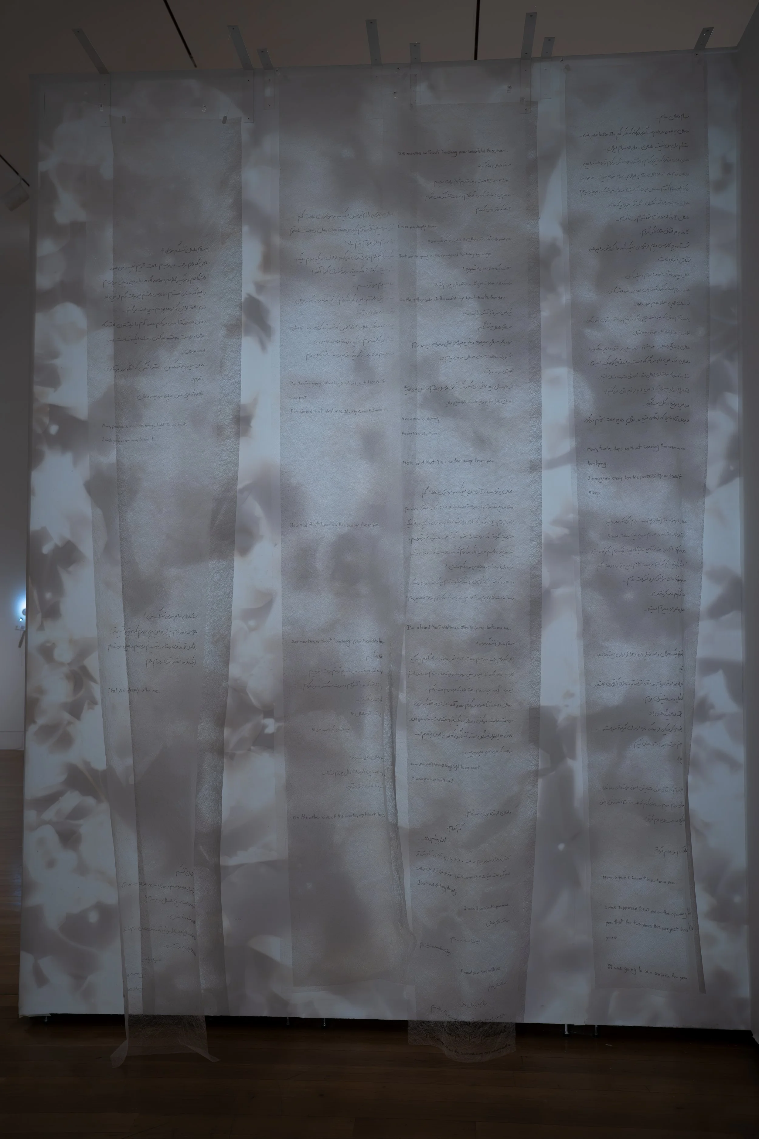 Zahra Momeni ,
Your Trace in the Farthest Nearness, 
2026, 
Mixed-media installation with overhead  
projection, photograms, transparent fabric,  
and handwritten text. 
Dimensions variable 