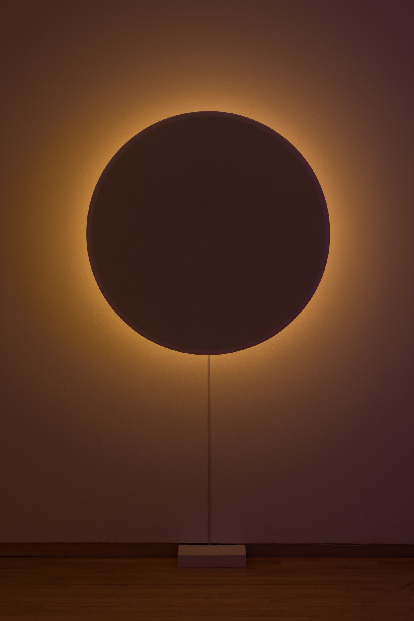 "In Totality" (still), 2025, Time-based installation view showing “Optic Disc (Yellow)," Retroreflective glass microspheres, acrylic paint, foam, steel, LED light, computer controller. 46” by 46” by 14” Photo credit: Neighboring States