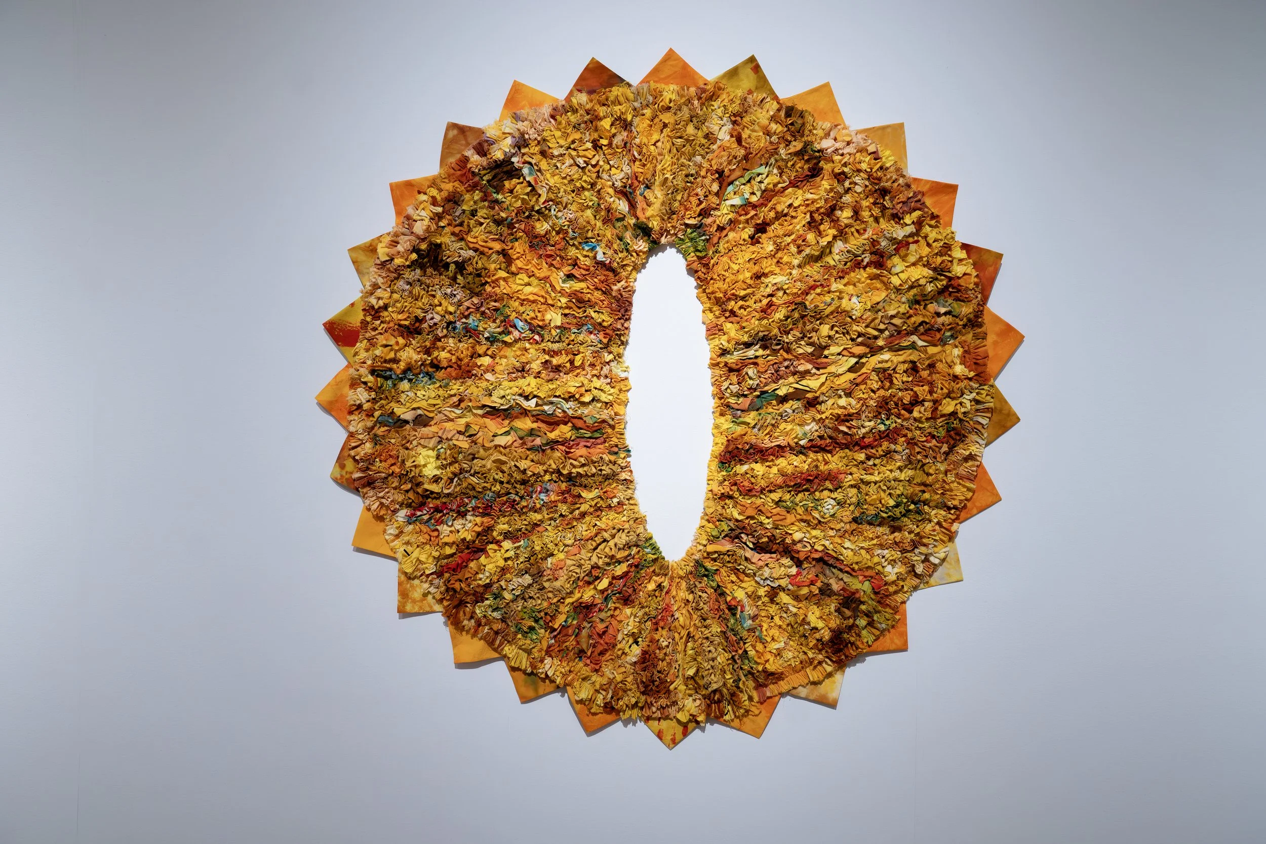 Will Grimm, 
O-Face, 
2026, 
Cotton fabric shreds, scraps, slivers, and rags  
collected from artist's practice, donation bins,  
trash cans, and Tyler floor; overdyed yellow. 
64" x 64" 