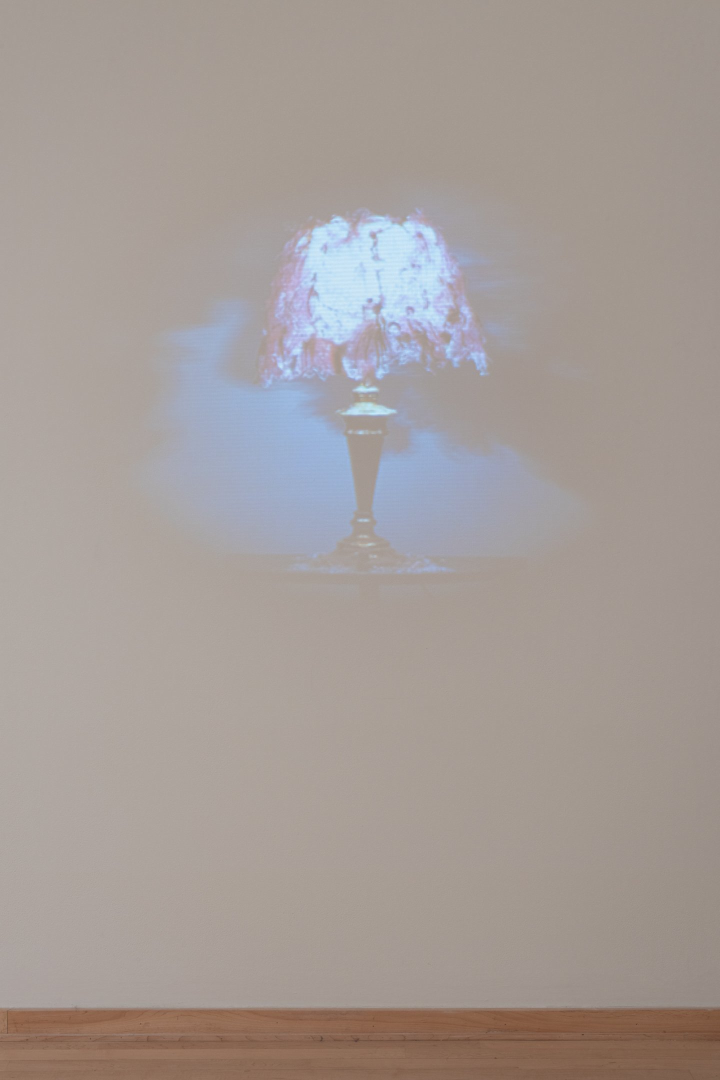 "Weeping Lamp" (still), 2025, Found Rug, Found Table, Found Lamp, Glass, Wax, Incandescent bulb, Paint, Gold Leaf Video, 5:00 minutes. Size Variable. Photo Credit: Neighboring Sates
