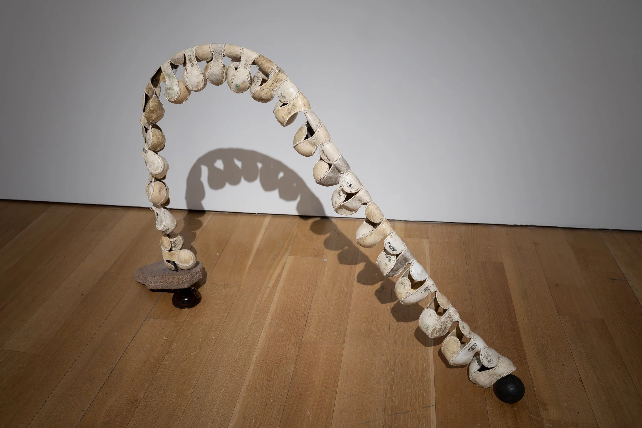 Mary Champagne, 
Spine, 
2026, 
Leather, silk, granite, steel, ball bearings, pine  
rosin, Darth Vader house key. 
42" x 10" x 36" 