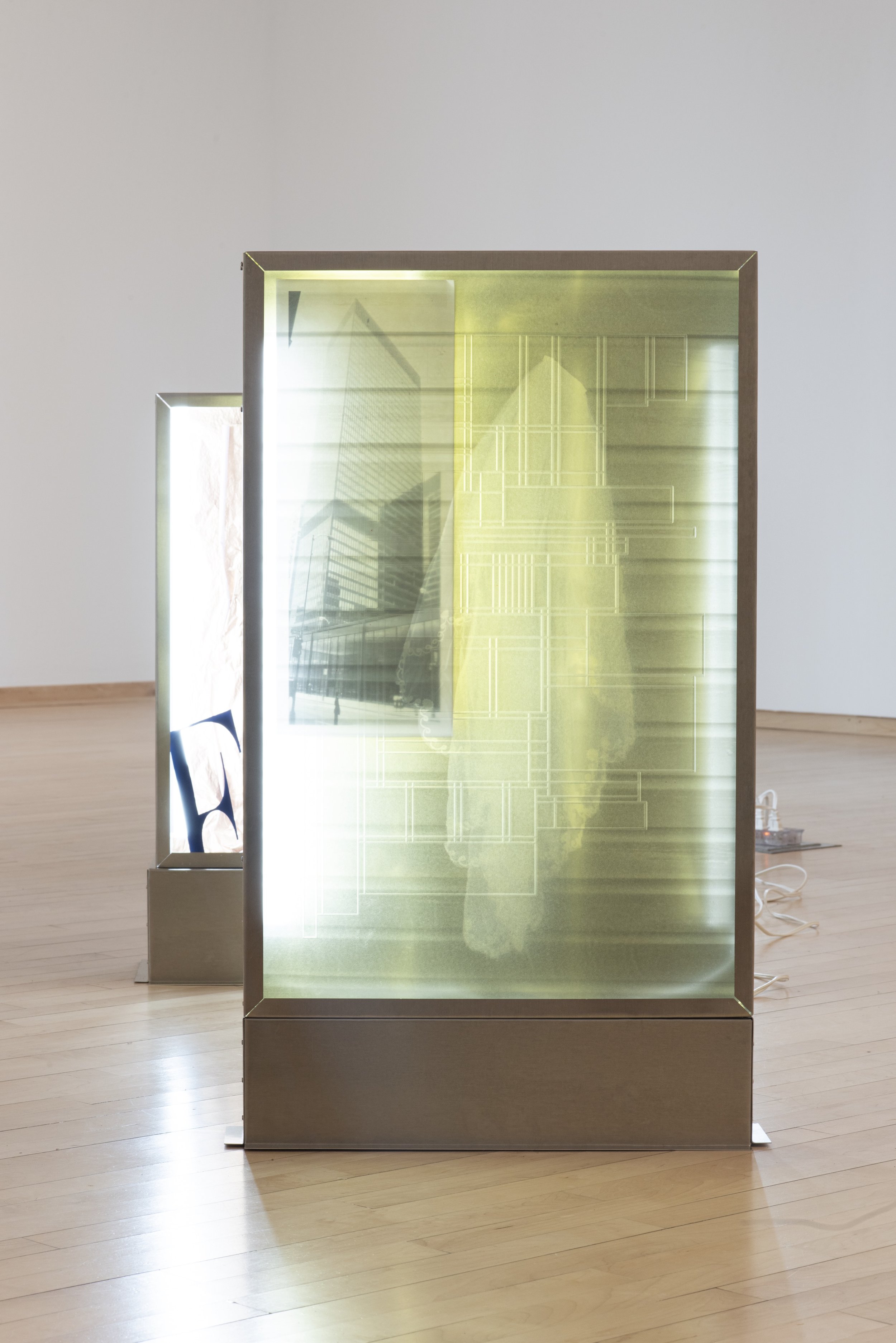 "Fatigue," Aluminum, plexiglass, LED tubes, machine screws, metallic table cloth, photograph on transparent film, inkjet photograph, packing tape, extension cord. 20" x 4" x 35", 2025, Photo Credit: Neighboring States