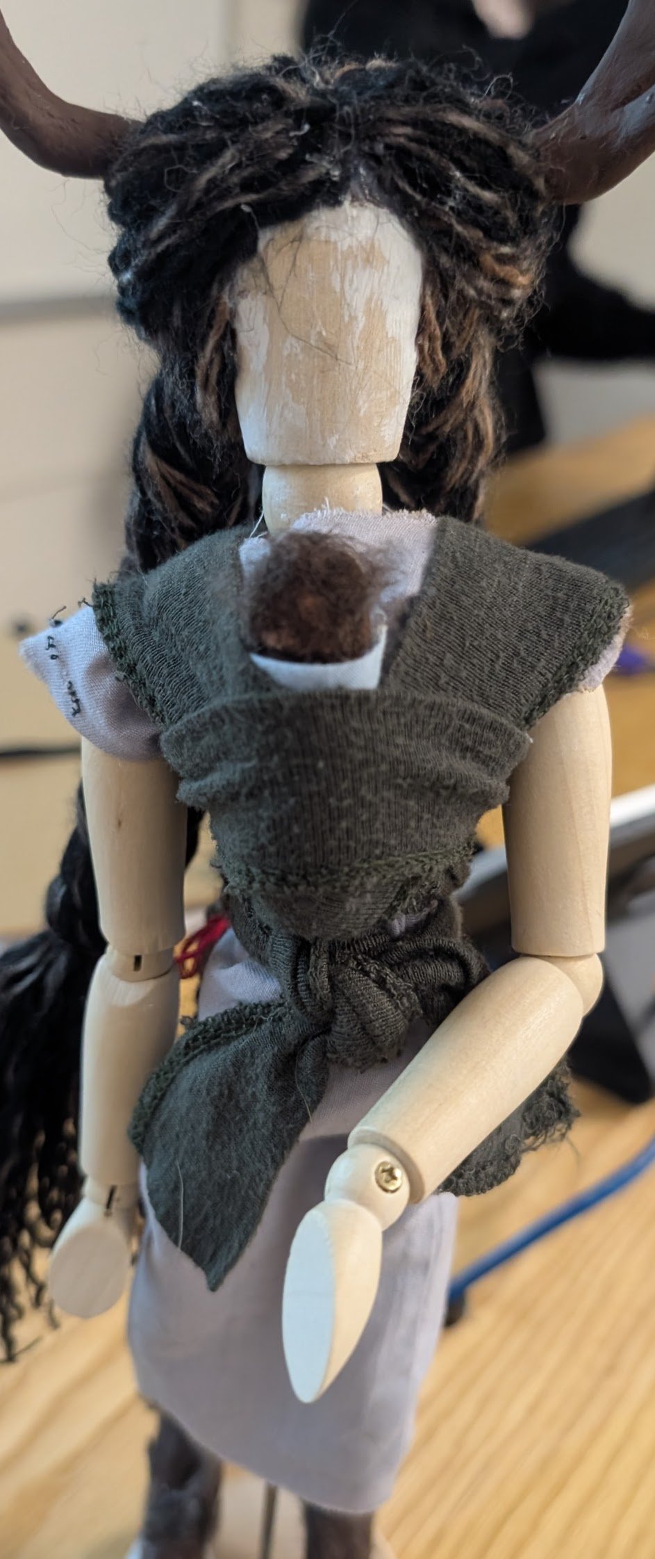 Deer Woman with Child, 2024, Mixed media: wooden figure model, air dry clay, acrylic yarn, t-shirt fabric, cotton fabric, hot glue, and metal wire, 12" x 12.6" x 2.8"