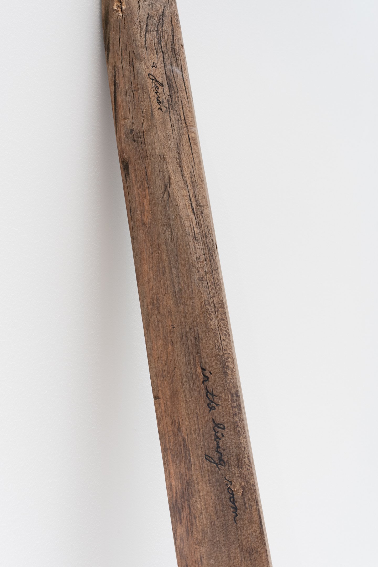 "In the living room peeling skins" (close-up), 2025, Reclaimed found wooden beam from a collapsed West Philadelphia home. Photo Credit: Neighboring States