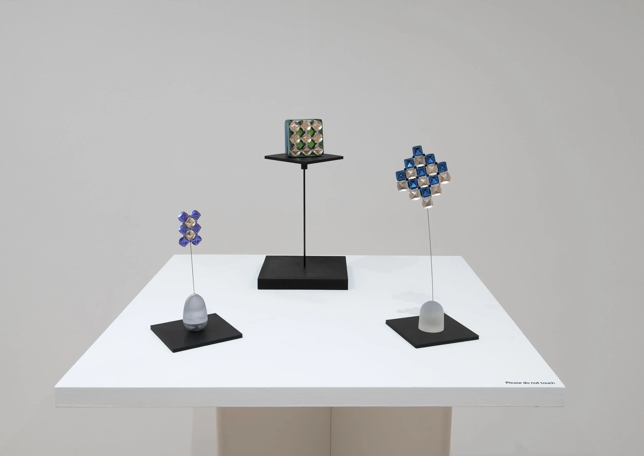 "Wobble Ring" (left)
Titanium,Sterling Silver,Steel,Resin. 0.7”x1.4”x5.9”. 
"Hesitating" (middle)
Titanium,Sterling Silver,Resin,Thread. 2.3”x2.3”x0.8”. 
"Sway" (right)
Titanium,Sterling Silver,Steel,Resin. 2.3”x2.3”x7.8”. 
Installation view. 
Photo 