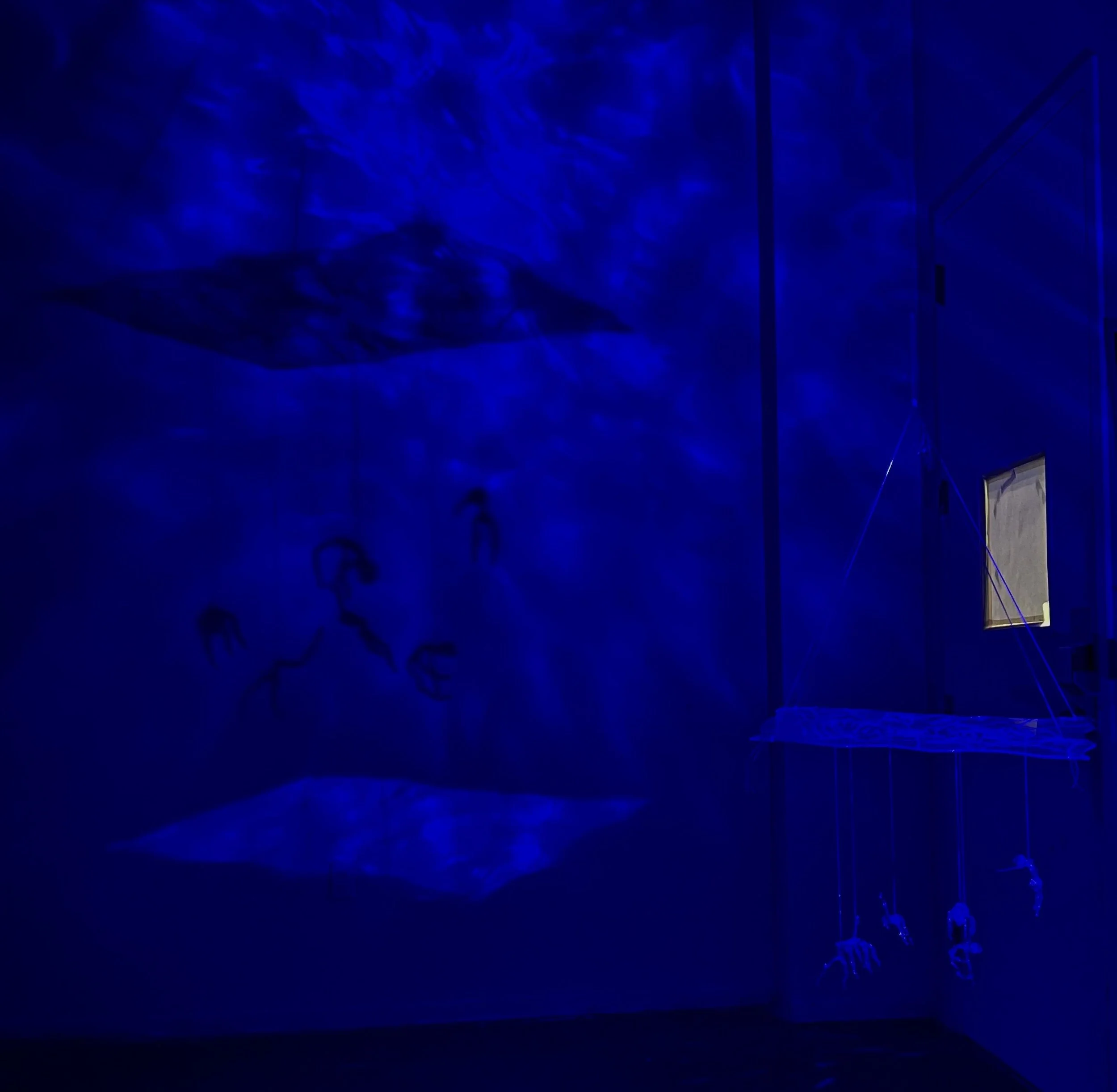 "Stuck Floating" 2024, Flameworked figures, Dremel glass engraving on glass sheet, 
projected lighting