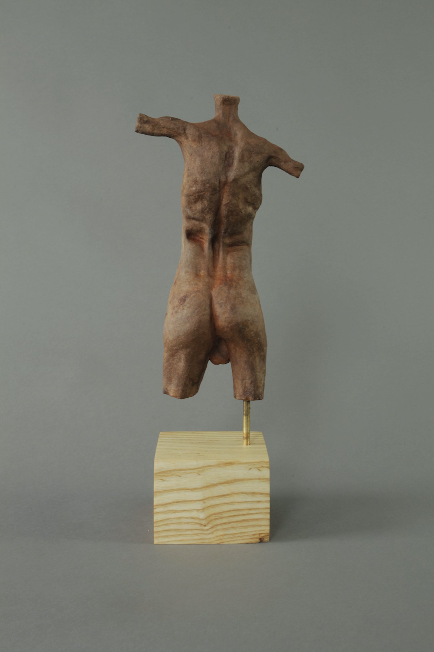 Zephyr's study in contrasts—'Torso (Rust),' a male torso sculpture in white concrete, showcasing meticulous details and a distinct rusty patina.