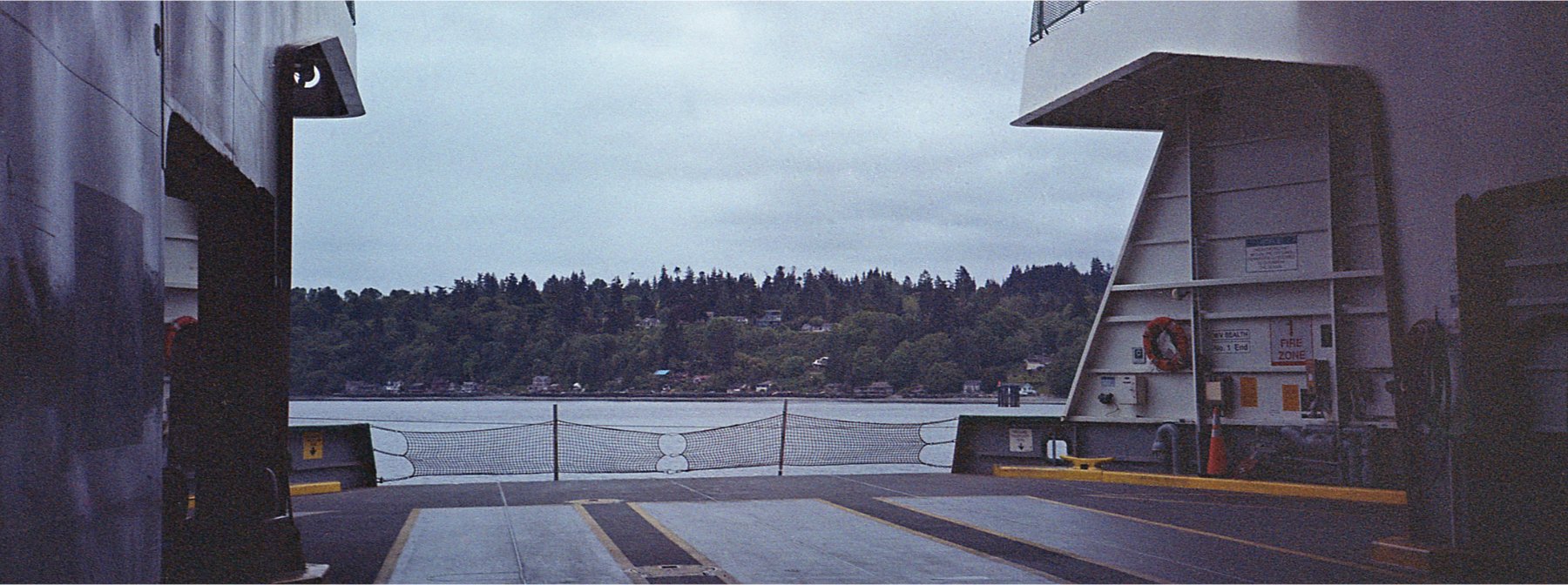 Picture of the water and land in the background looking out from Fauntleroy/Southworth ferry car deck, taken on Fujifim 400 with my Canon sure shot.