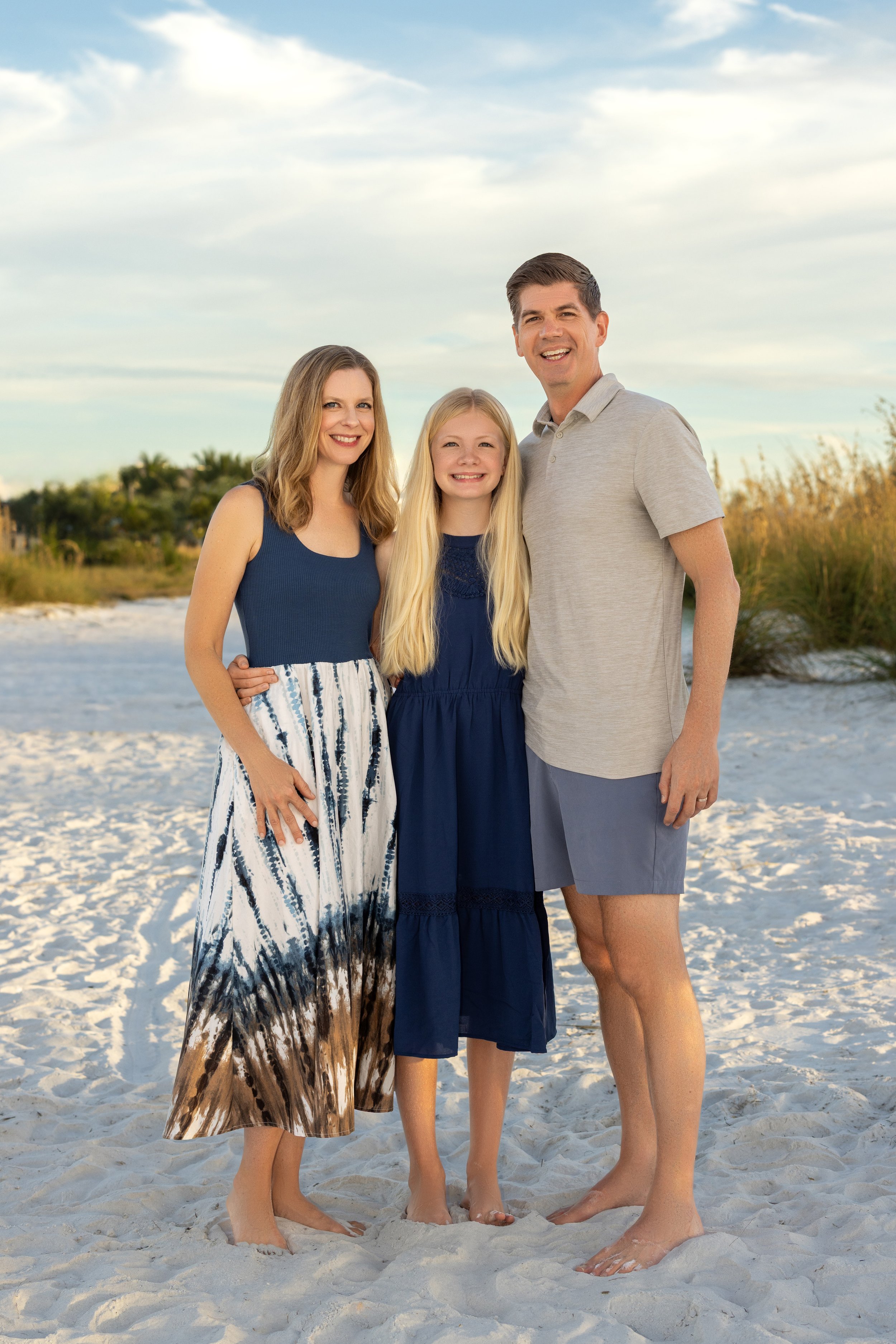 Family of three pose for portrait on anna maria island, FL