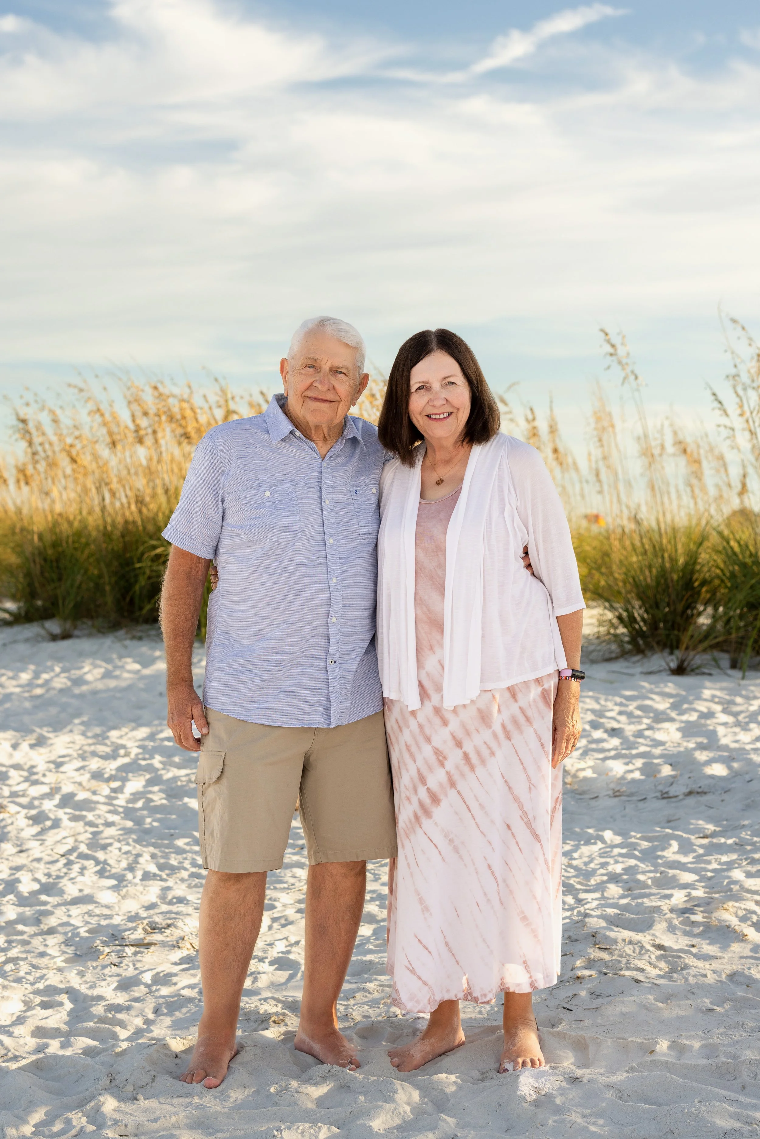 Grandparents pose for portrait on beach on anna maria island, FL