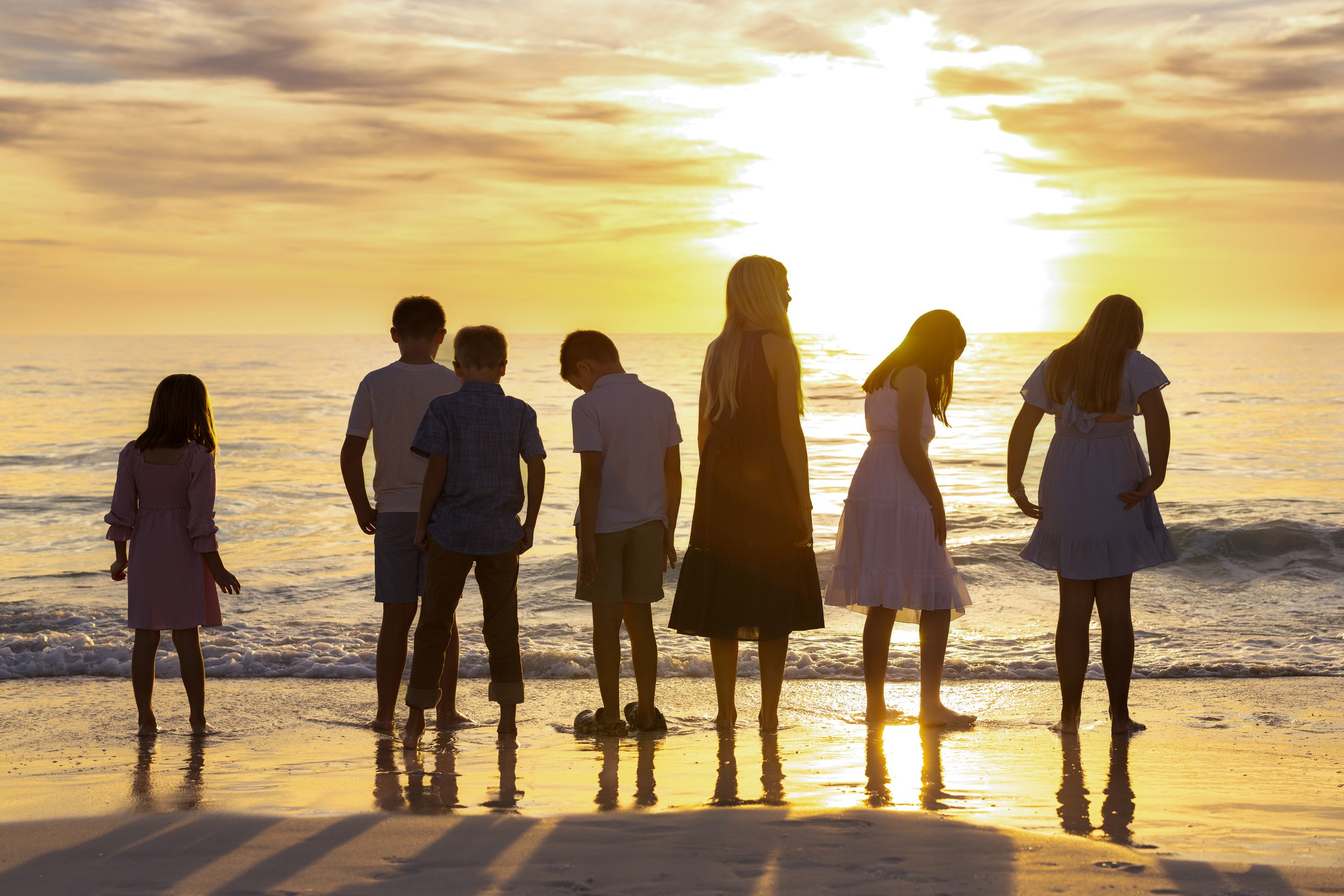 Sunset backlit photo of kids standing in Gulf of Mexico