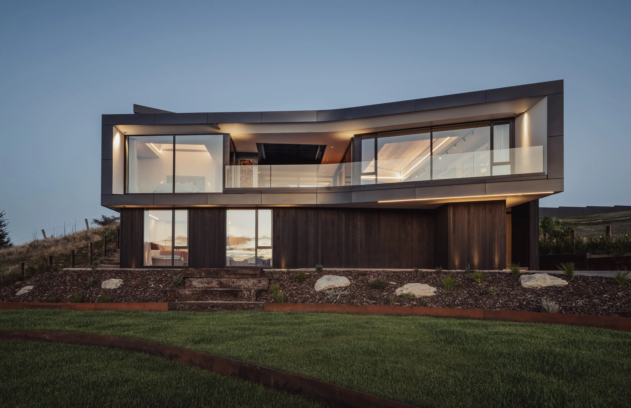 All Elements tiered landscaping featuring manicured, curved lawns edged with Corten steel