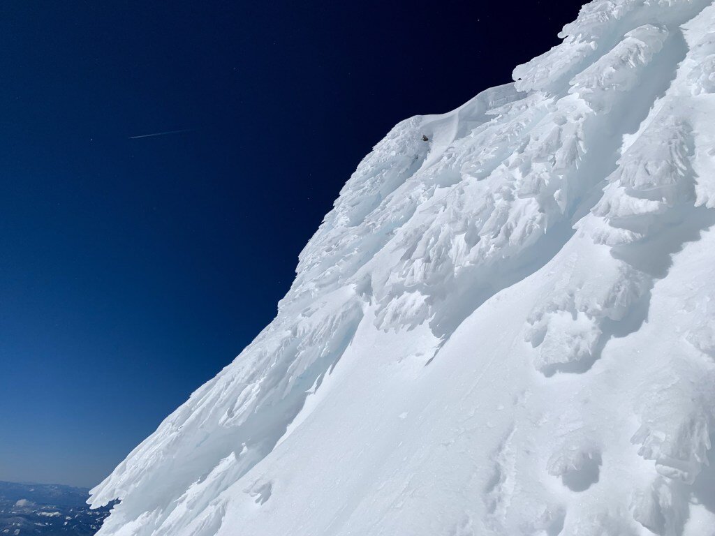 Rime ice: “a white&nbsp;ice&nbsp;that forms when the water droplets in fog freeze to the outer surfaces of objects. It is often seen on trees atop mountains and ridges in winter, when low-hanging clouds cause freezing fog.”