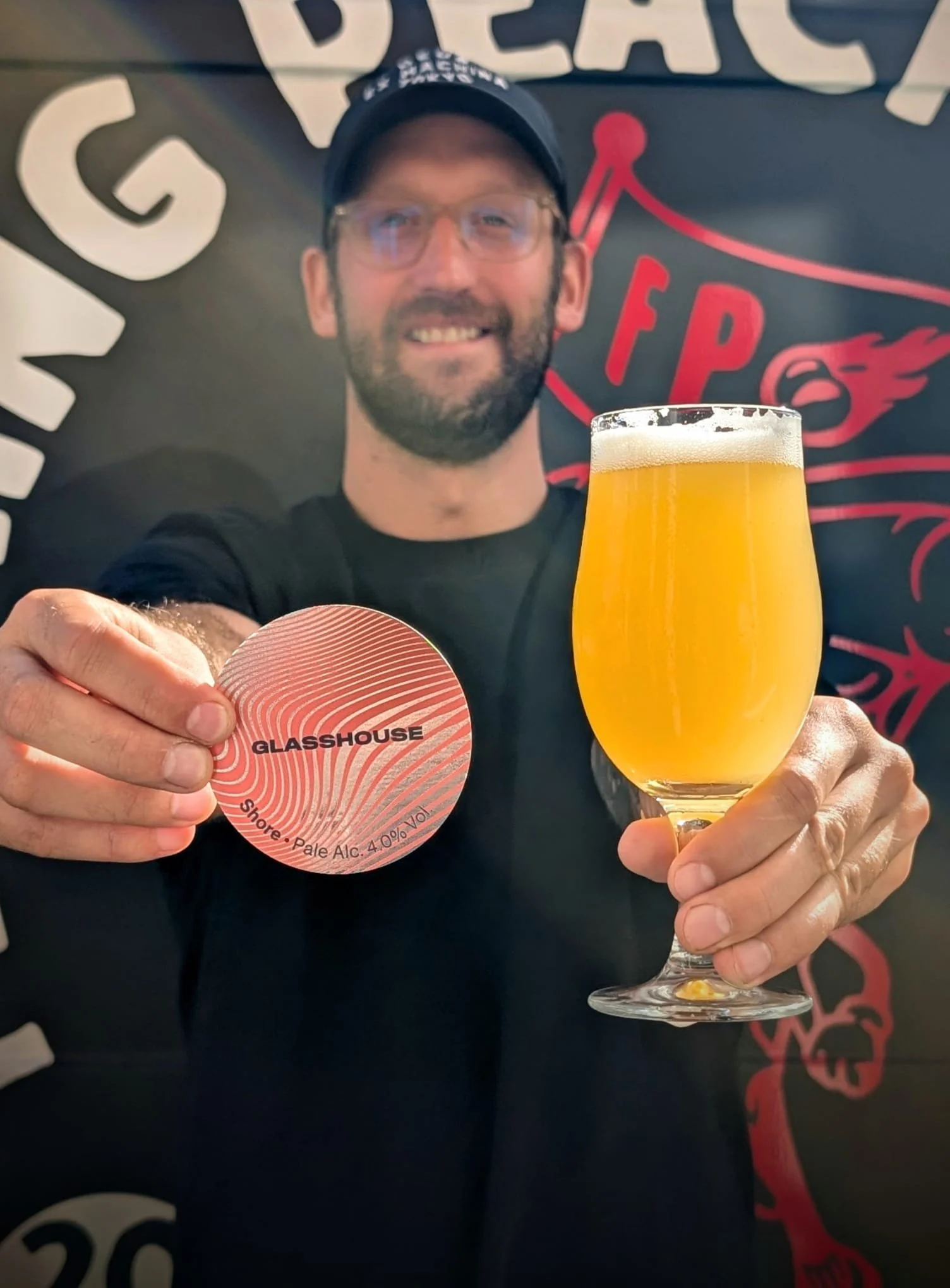 Man holding a schooner of craft beer