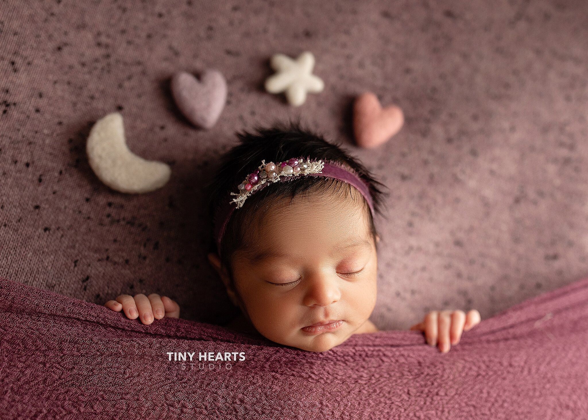Baby girl asleep with moon, stars, and heart props
