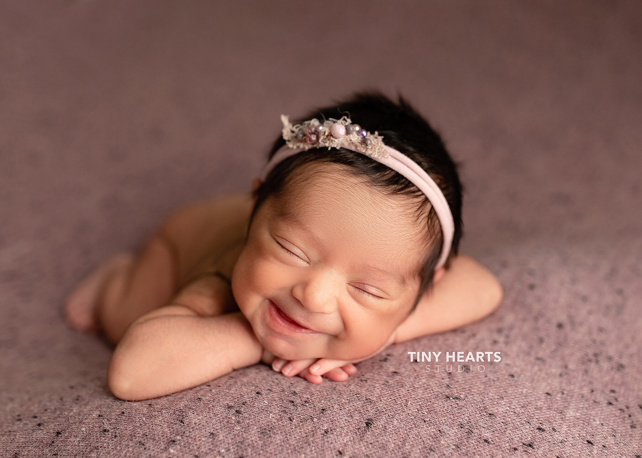 newborn girl asleep and smiling, St. Cloud newborn photography studio