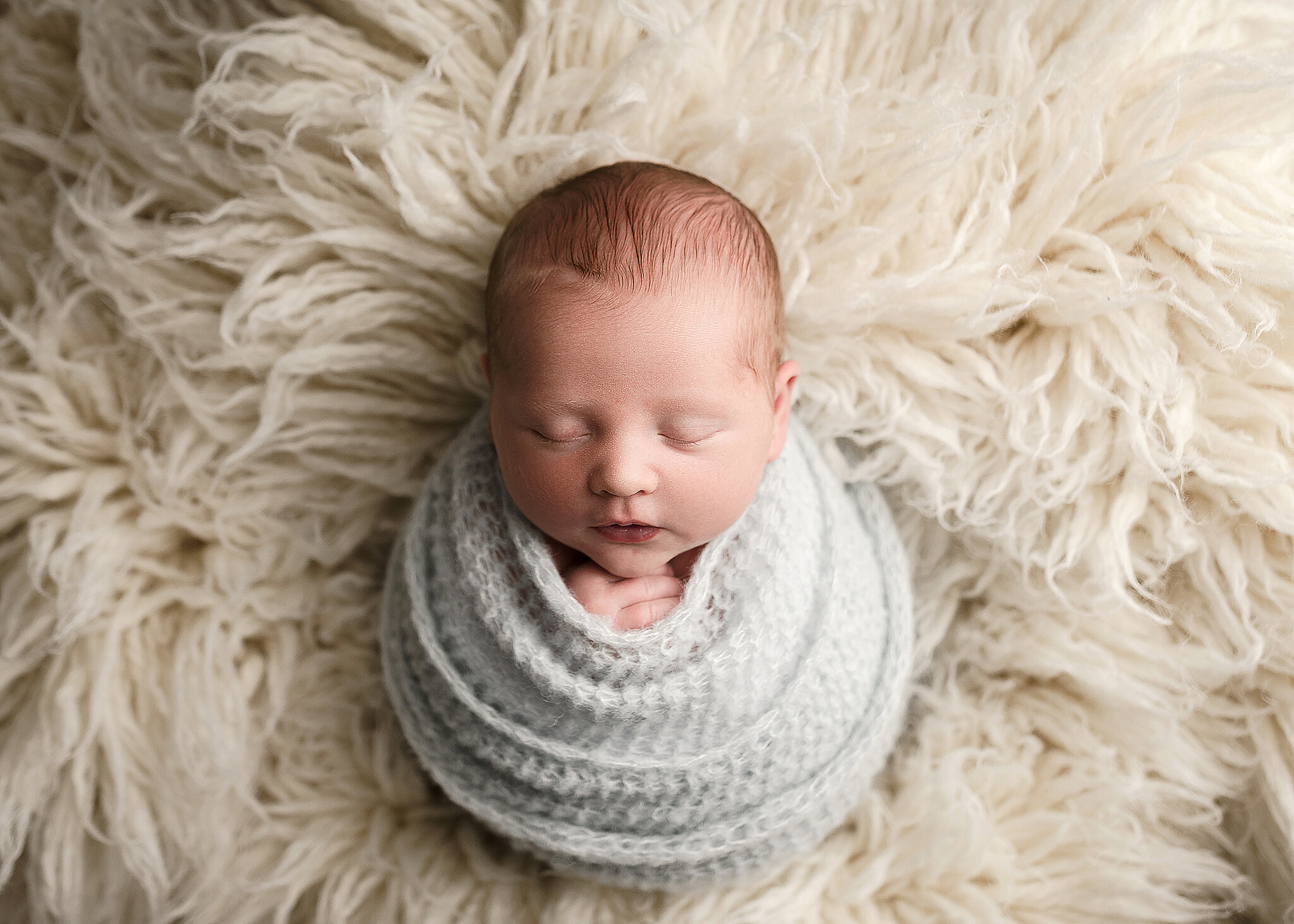 newborn photography, swaddled baby boy on flokati