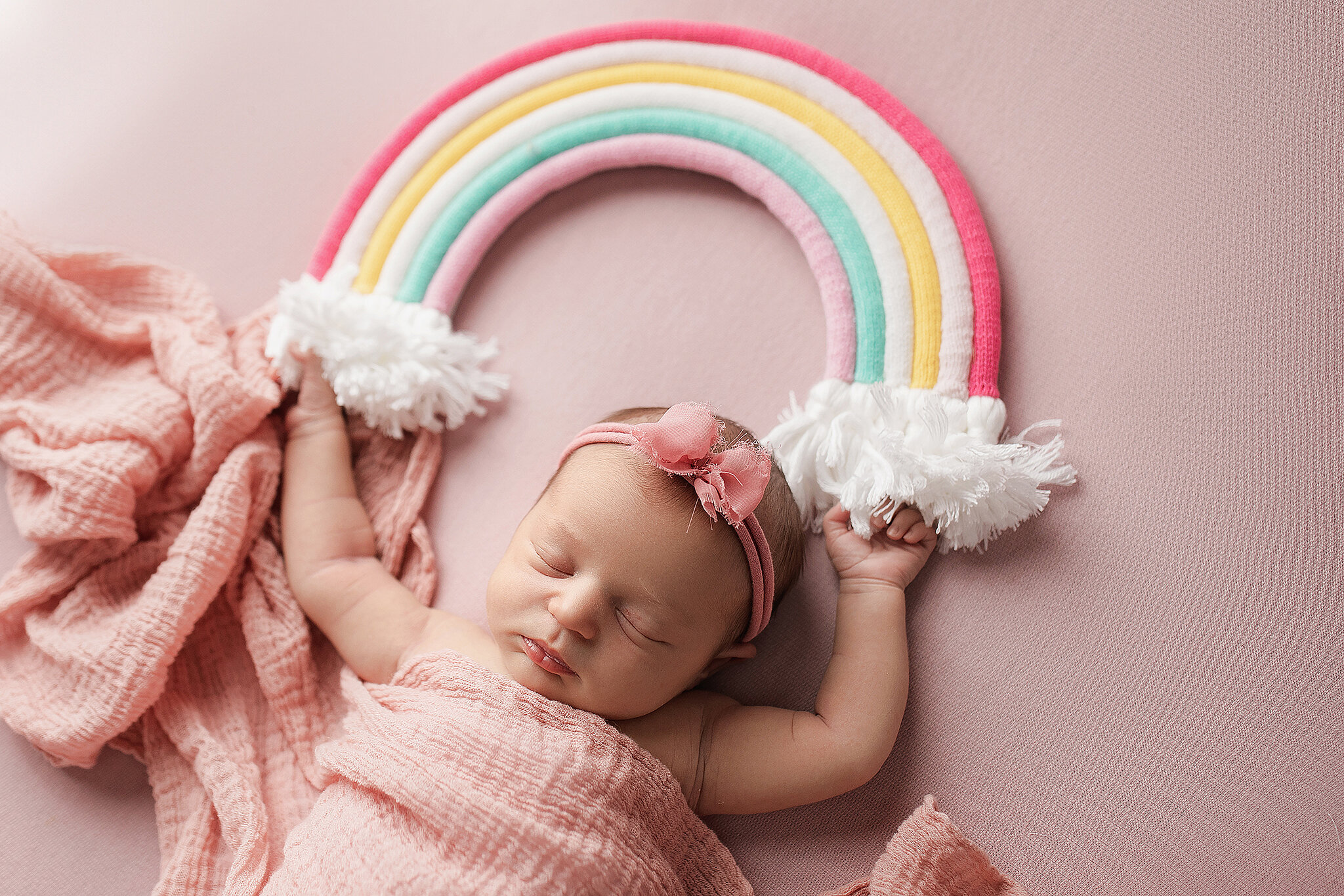 newborn girl with rainbow prop