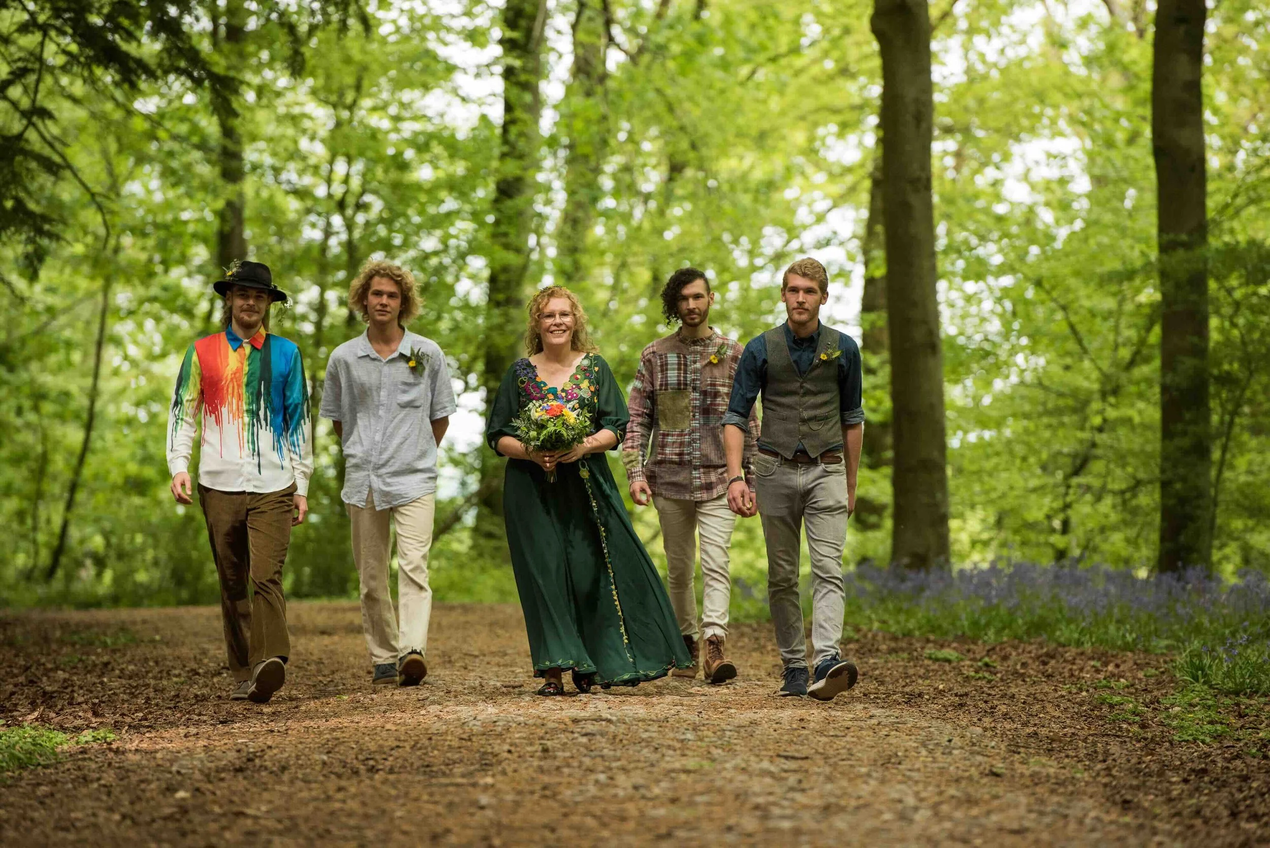 Bride and her boys arriving at wedding ceremony for handfasting in bluebell woods of Erlestoke, Wiltshire