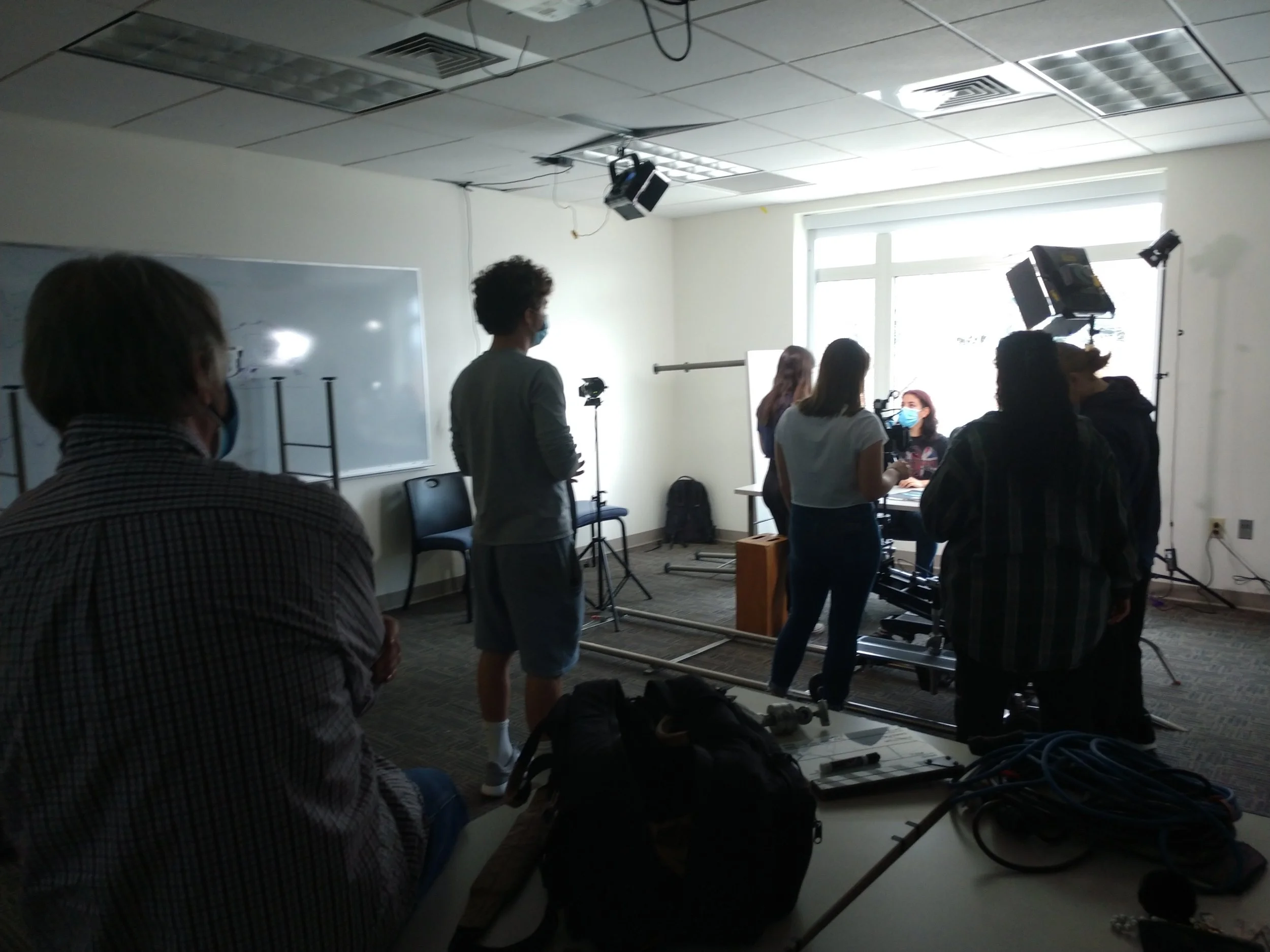 Indoor scene of a filming crew with cameras and lighting set up