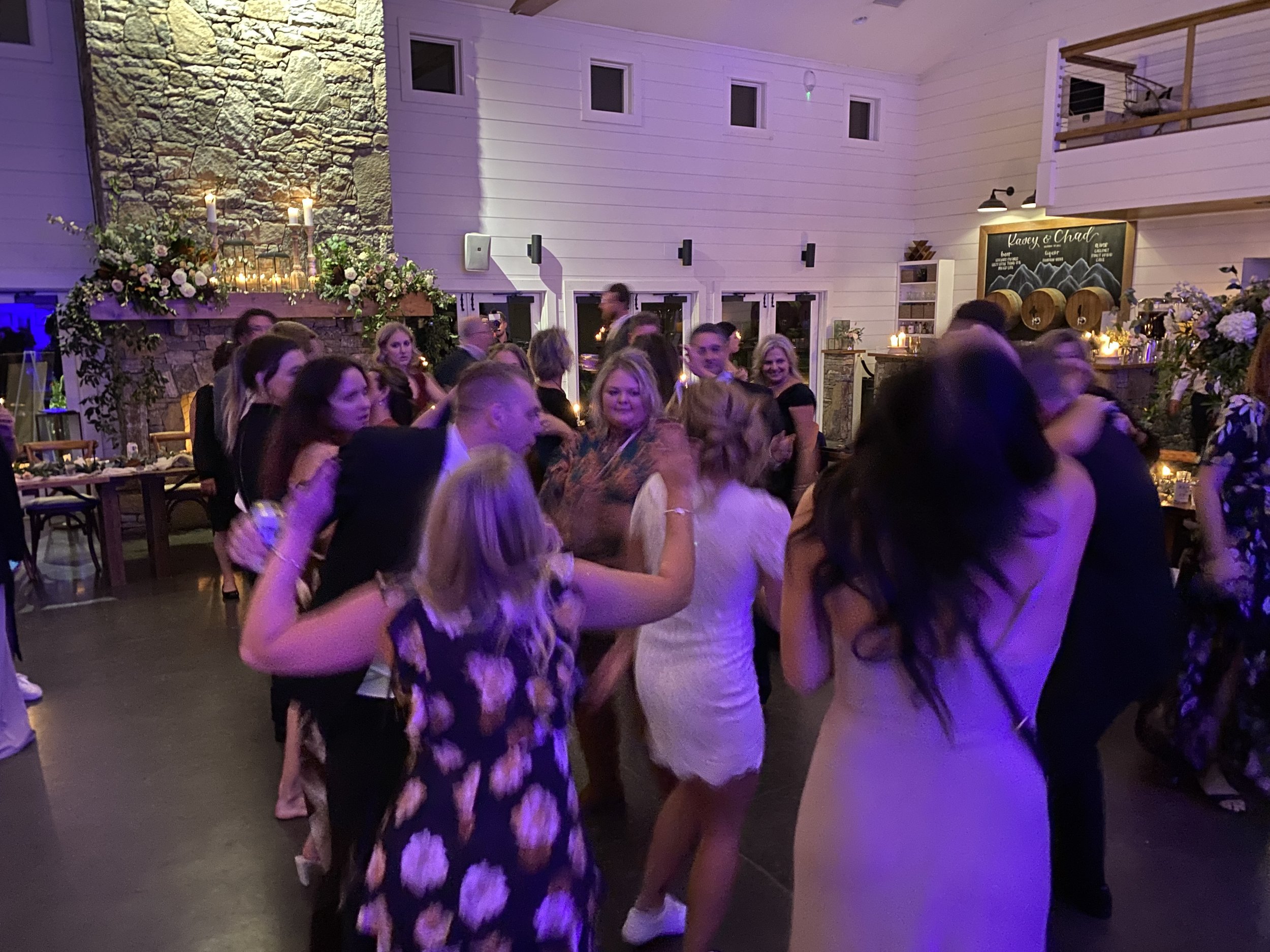 Wedding guests dancing under purple reception lighting at Chestnut Ridge in Canton, North Carolina