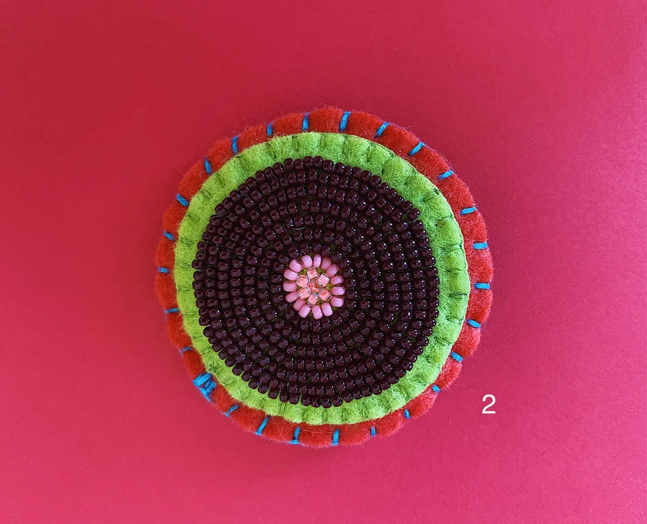 Photo of option 2: a colorful hand-sewn & beaded felt brooch of various skin tones that looks like tatas.