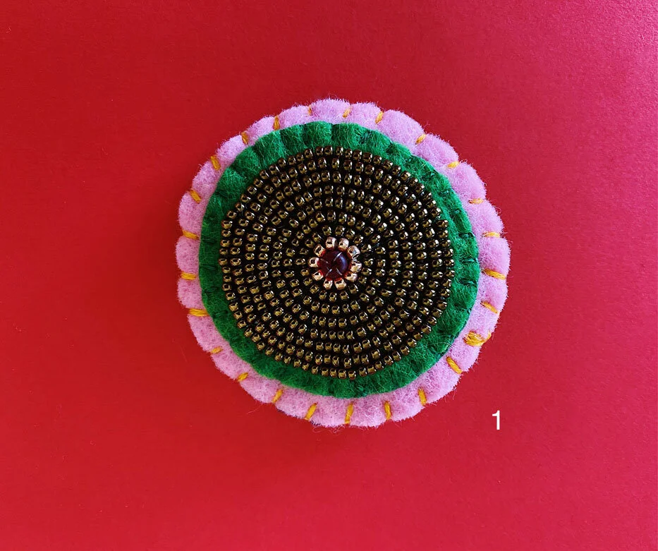 Photo of option 1: a colorful hand-sewn & beaded felt brooch of various skin tones that looks like tatas.